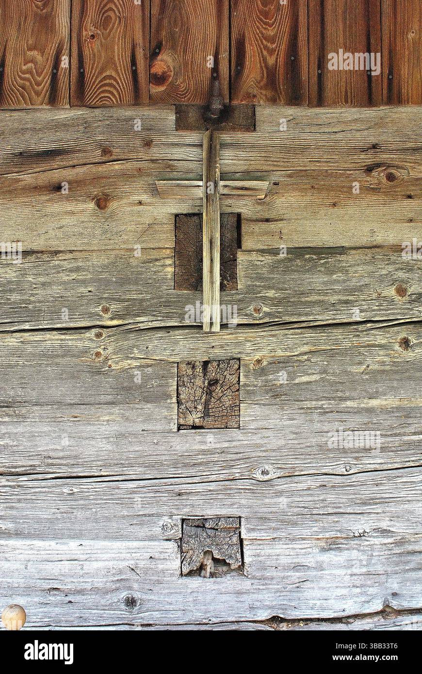 Sein Bild zeigt eine rustikale Holzstruktur mit einem Kreuz. Perfekt für Liebhaber von Vintage-Dekorationen und rustikalem Charme. Stockfoto
