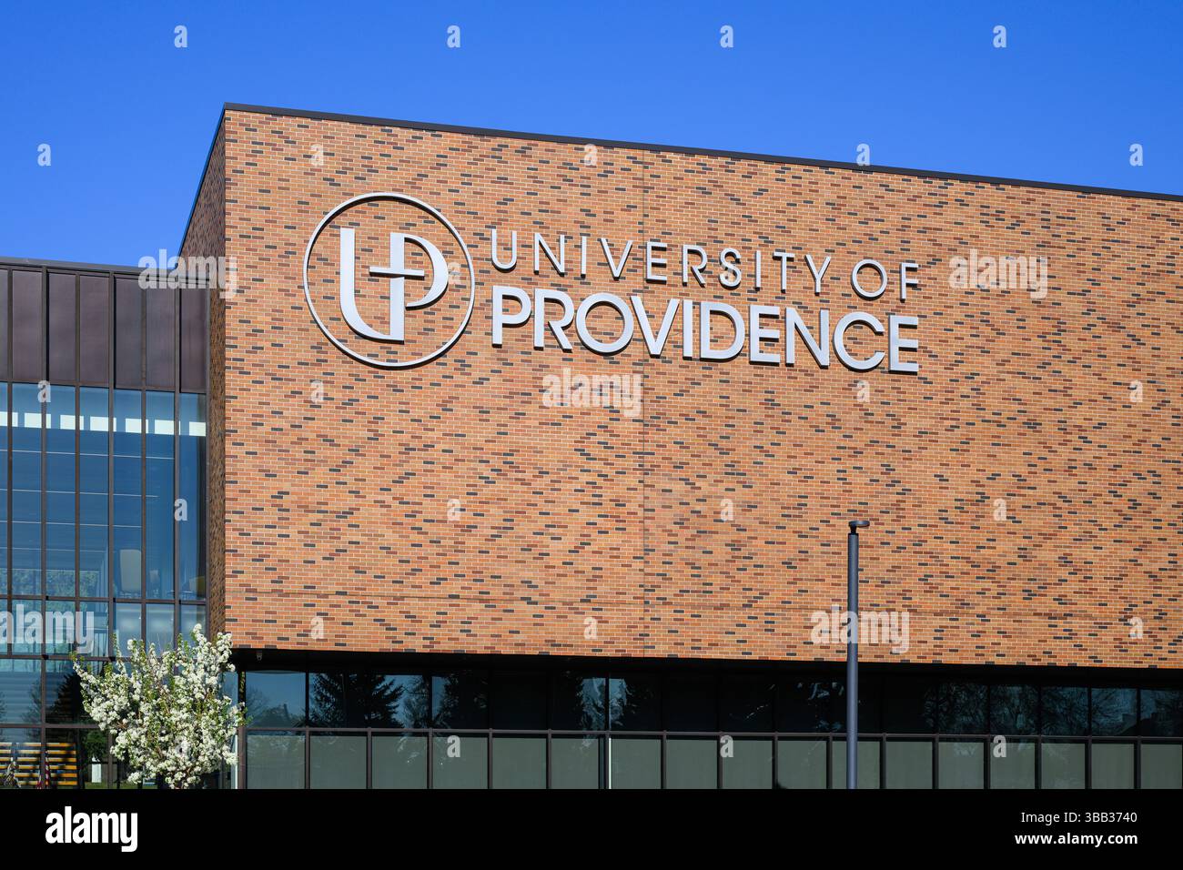 Great Falls, MT, USA - 3. Mai 2025; Schild an der Backsteinmauer an der University of Providence mit katholischer intellektueller Tradition Stockfoto