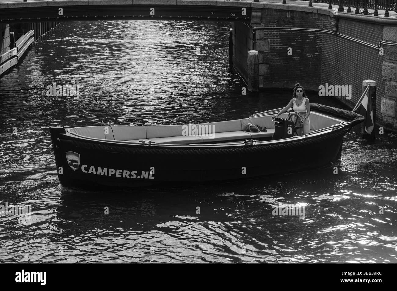 Frau im kleinen Boot, auf dem Amsterdamer Kanal (Schwarz/weiß ) Stockfoto