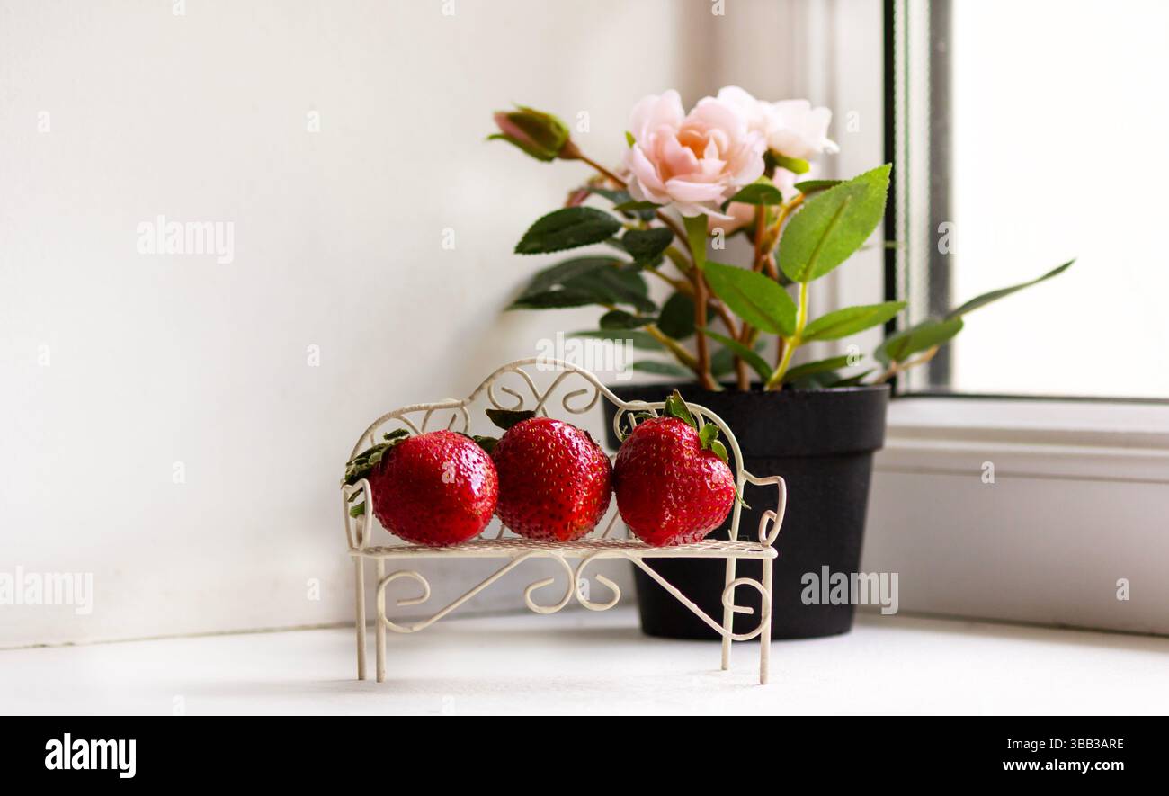 Erdbeeren auf einer kleinen Vintage-Bank. Schönheits- und Essensdesign Stockfoto