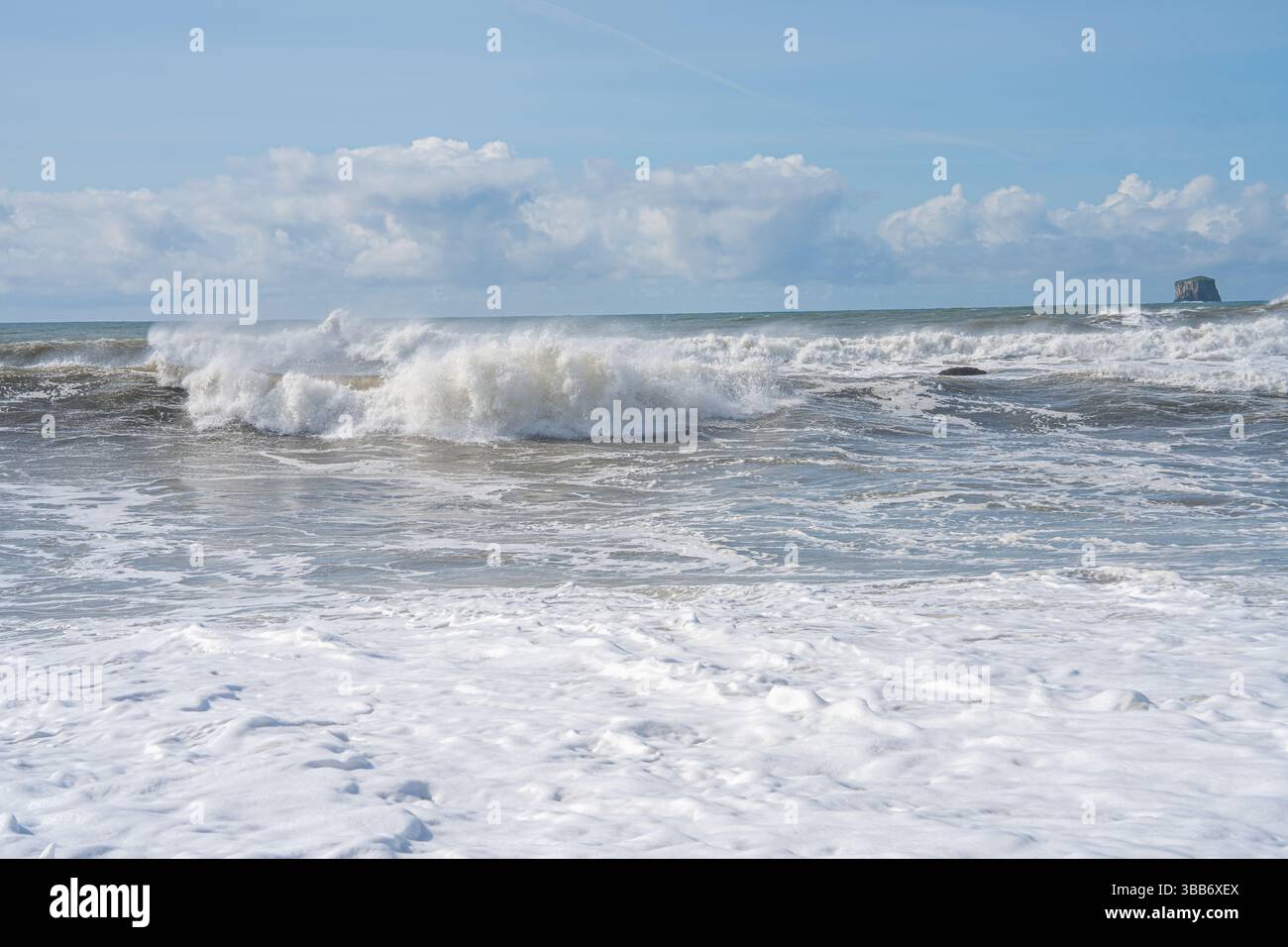 Schaumige Wellen krachen und Rollen im Pazifik unter einem hellblauen Himmel. Stockfoto