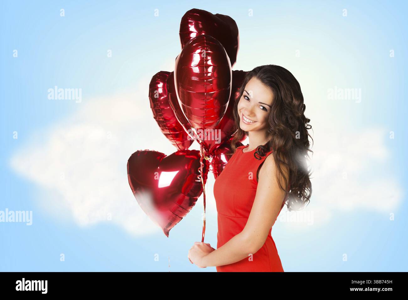 Junge schöne Frau im roten Kleid mit Luftballons auf dem Himmelshintergrund Stockfoto