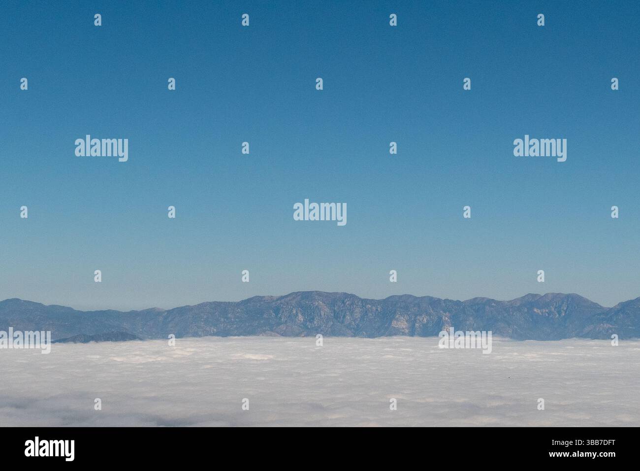 Aus der Vogelperspektive auf die San Gabriel Mountain Range außerhalb von Los Angeles mit Wolken, die das Pomona Valley darunter bedecken Stockfoto
