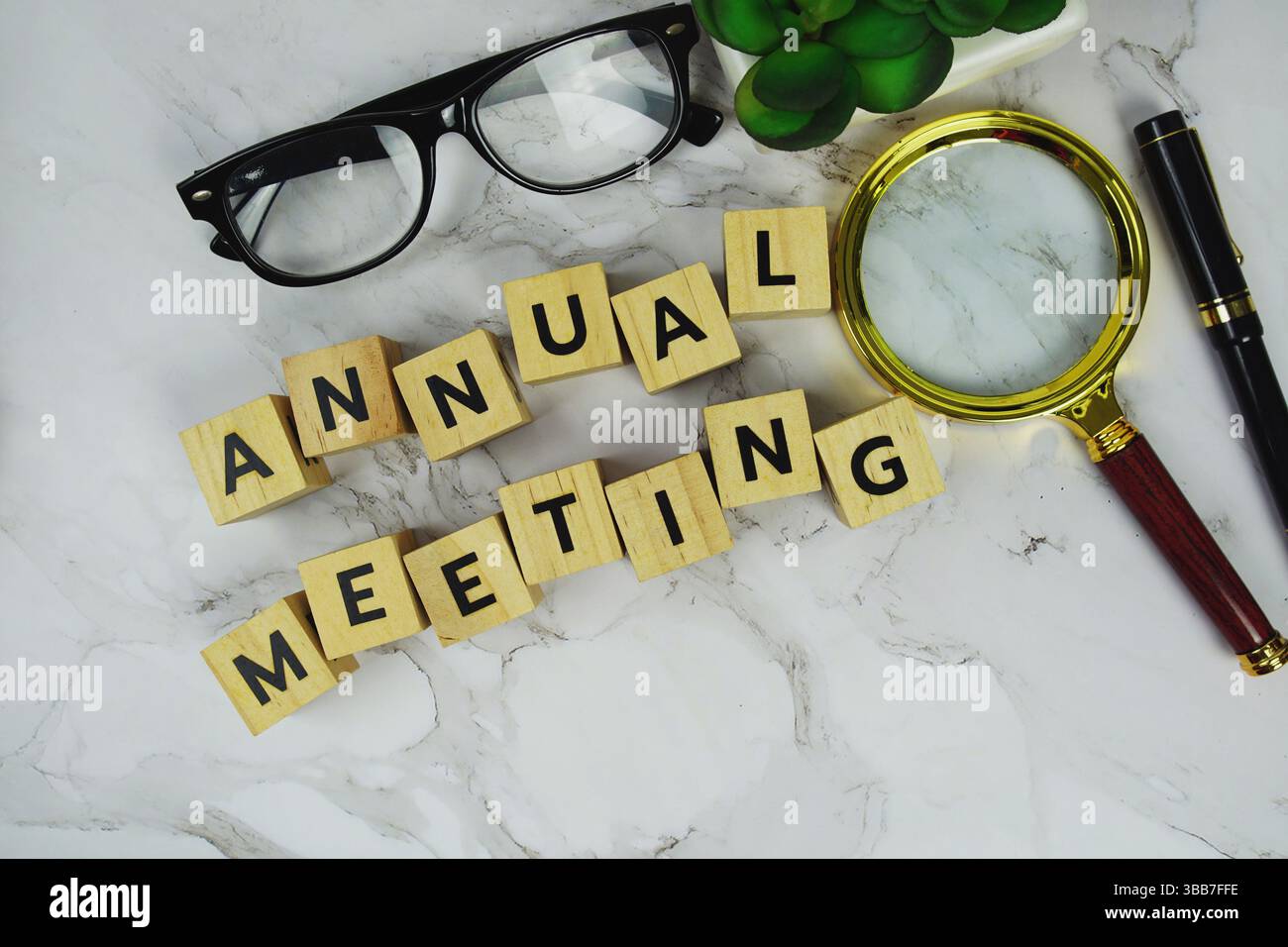 Annaul trifft sich mit Holzblöcken Alphabetbuchstaben und Vergrößerungsglas auf Marmorhintergrund Stockfoto