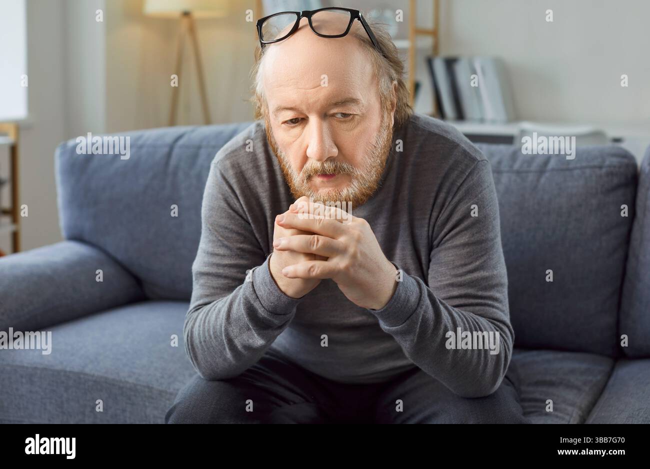 Trauriger, nachdenklicher, gelangweilter älterer Mann allein, der deprimiert, frustriert, einsam und leidend wirkt Stockfoto