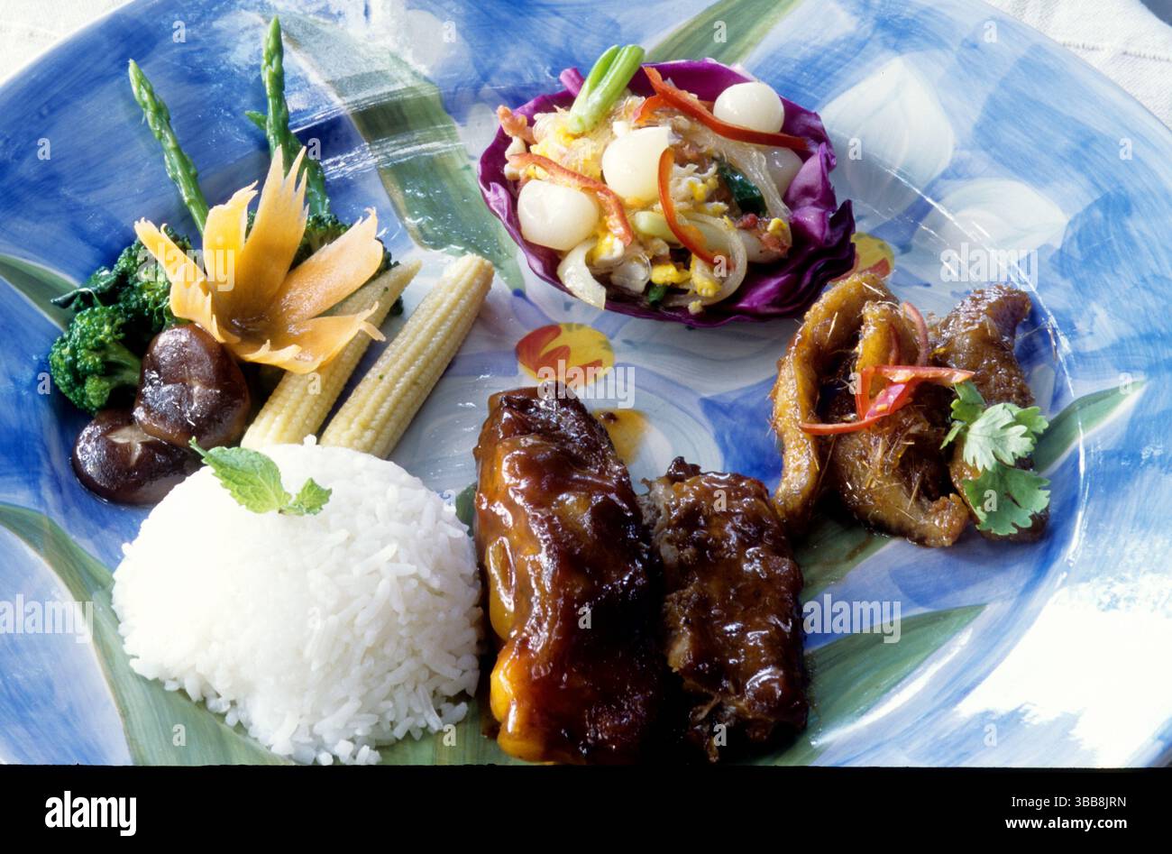 Ein wunderschönes Gericht mit einer Vielfalt asiatisch inspirierter Küche. Der Teller umfasst gedämpften Reis, glasierte Rippchen und gebratenes Gemüse. Stockfoto