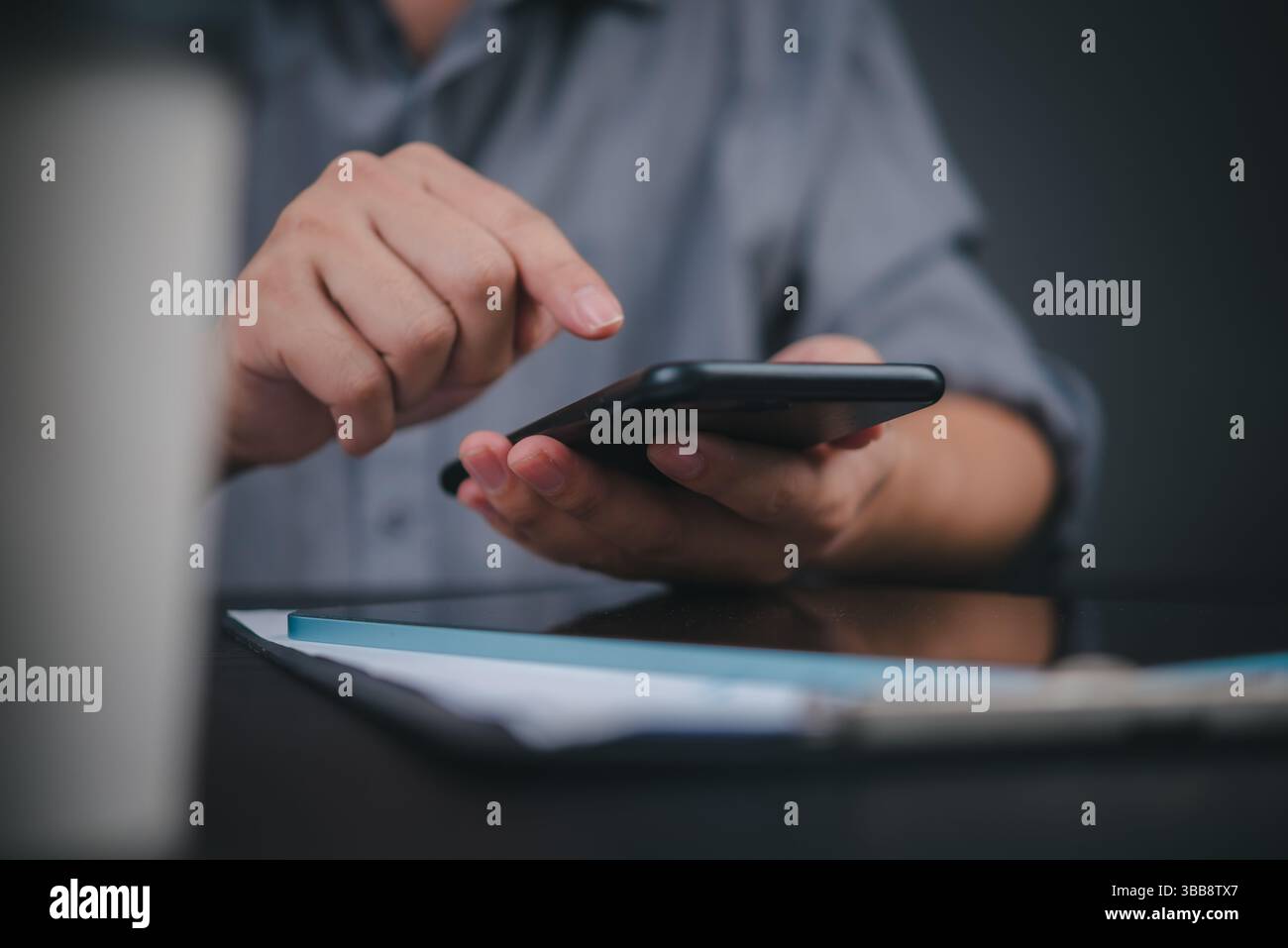 Handbedienung Handy am Arbeitsplatz, Business Lifestyle. Moderne Büromitarbeiter mit mobiler Technologie, professionelle Umgebungsaufnahmen mit DO Stockfoto