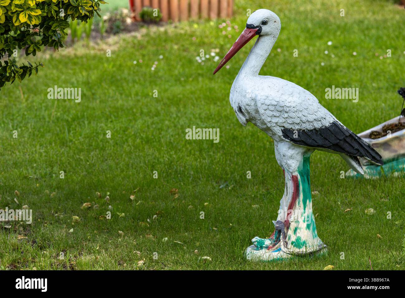 Eine dekorative Storchfigur auf dem Rasen vor dem Haus im Garten Stockfoto