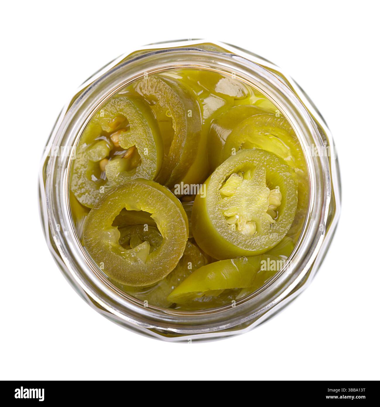 Eingelegte grüne Jalapeno-Scheiben in einem offenen Glas mit Schraubverschluss, isoliert, von oben. Mittelgroße, heiße, grüne Chilischoten, in Querschnitte geschnitten. Stockfoto