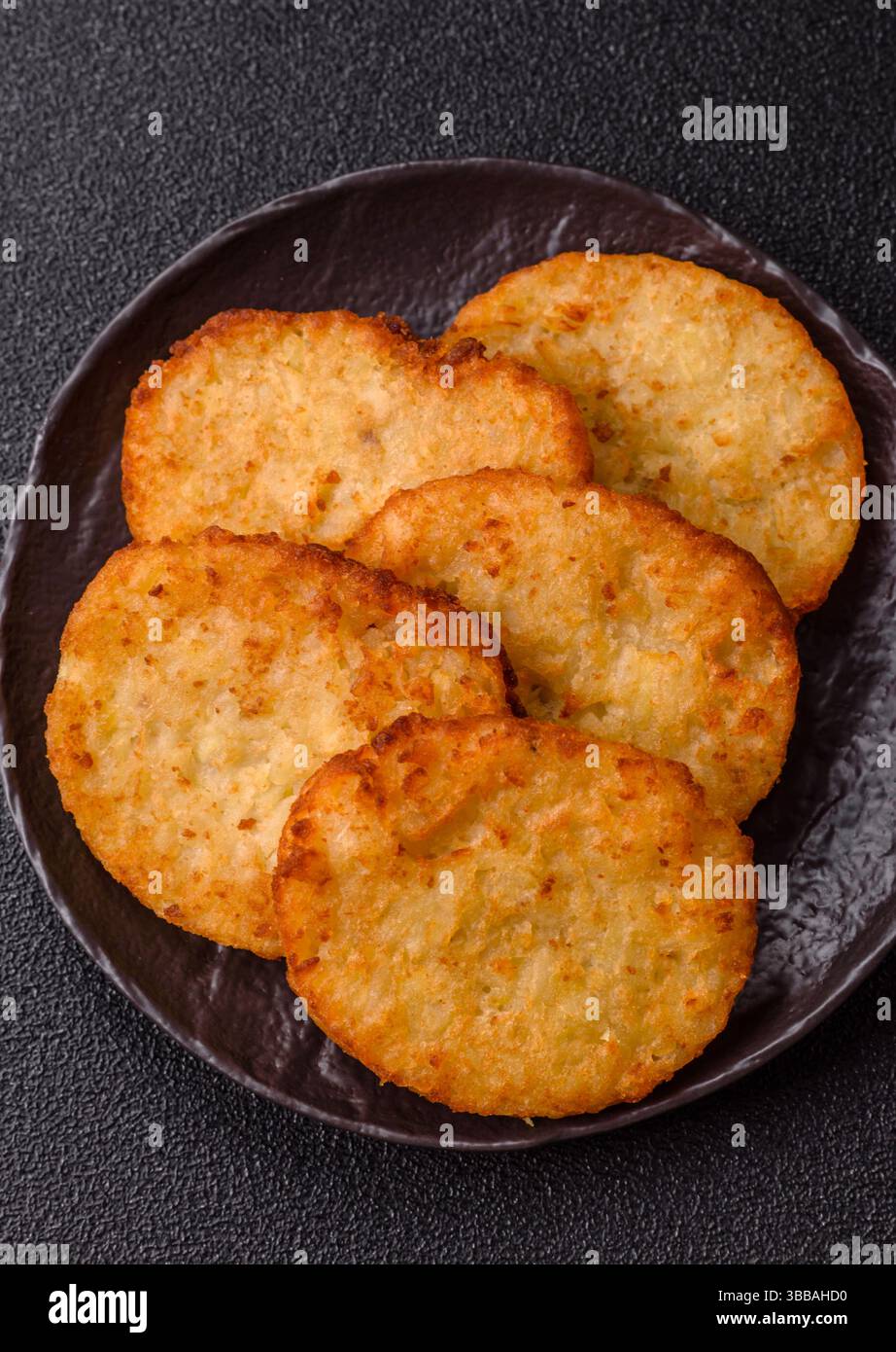 Kartoffelrösti, eine Mahlzeit mit Zwiebeln, Kohl in Form von Krapfen. Vegetarisches gesundes Frühstück Stockfoto