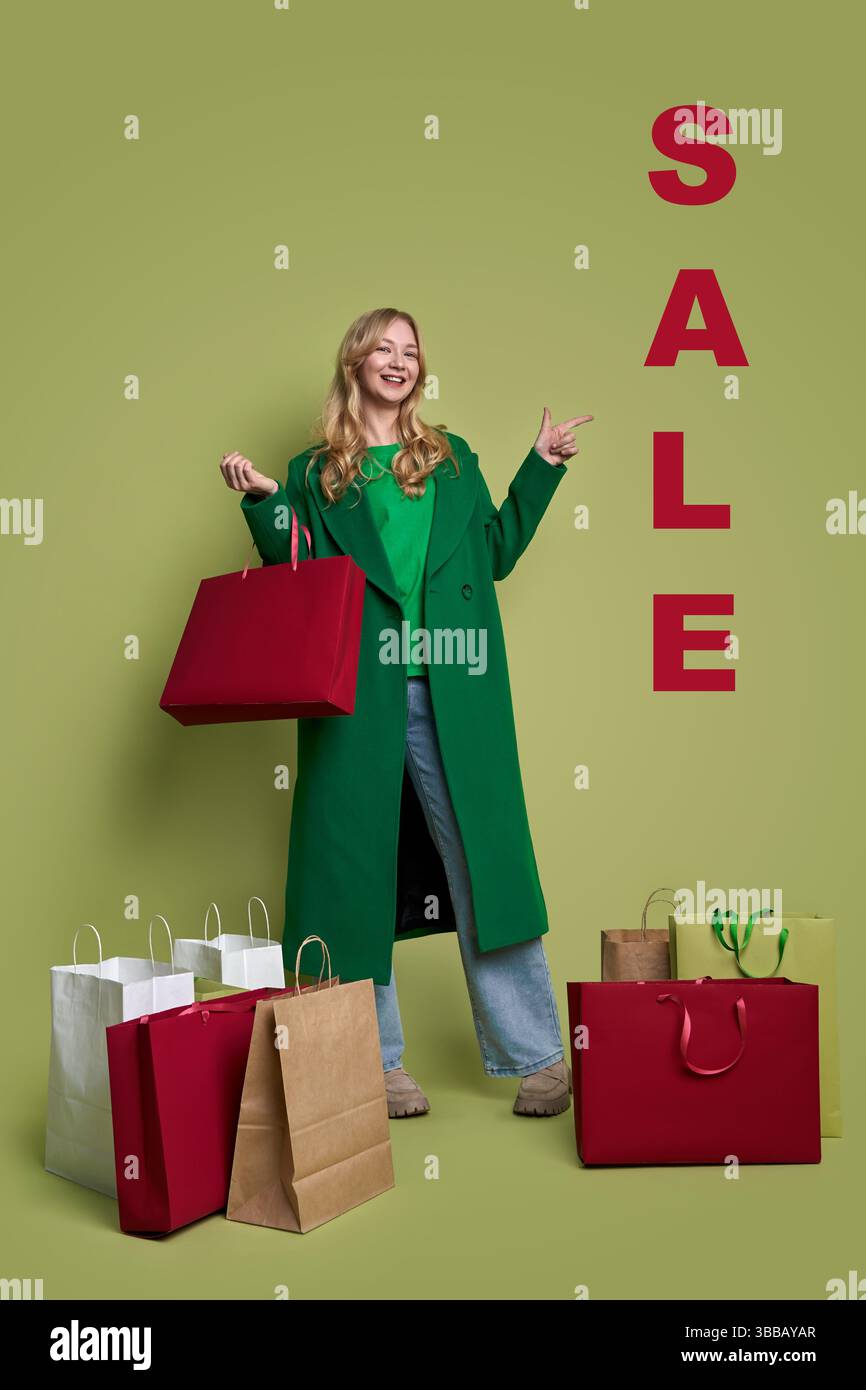 Junge weiße Frau mit Einkaufstaschen auf olivem Hintergrund Stockfoto