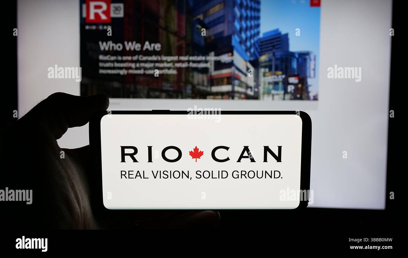 Stuttgart, Deutschland - 01-02-2024: Person mit Mobiltelefon mit Logo der Firma RioCan Real Estate Investment Trust auf dem Bildschirm Stockfoto