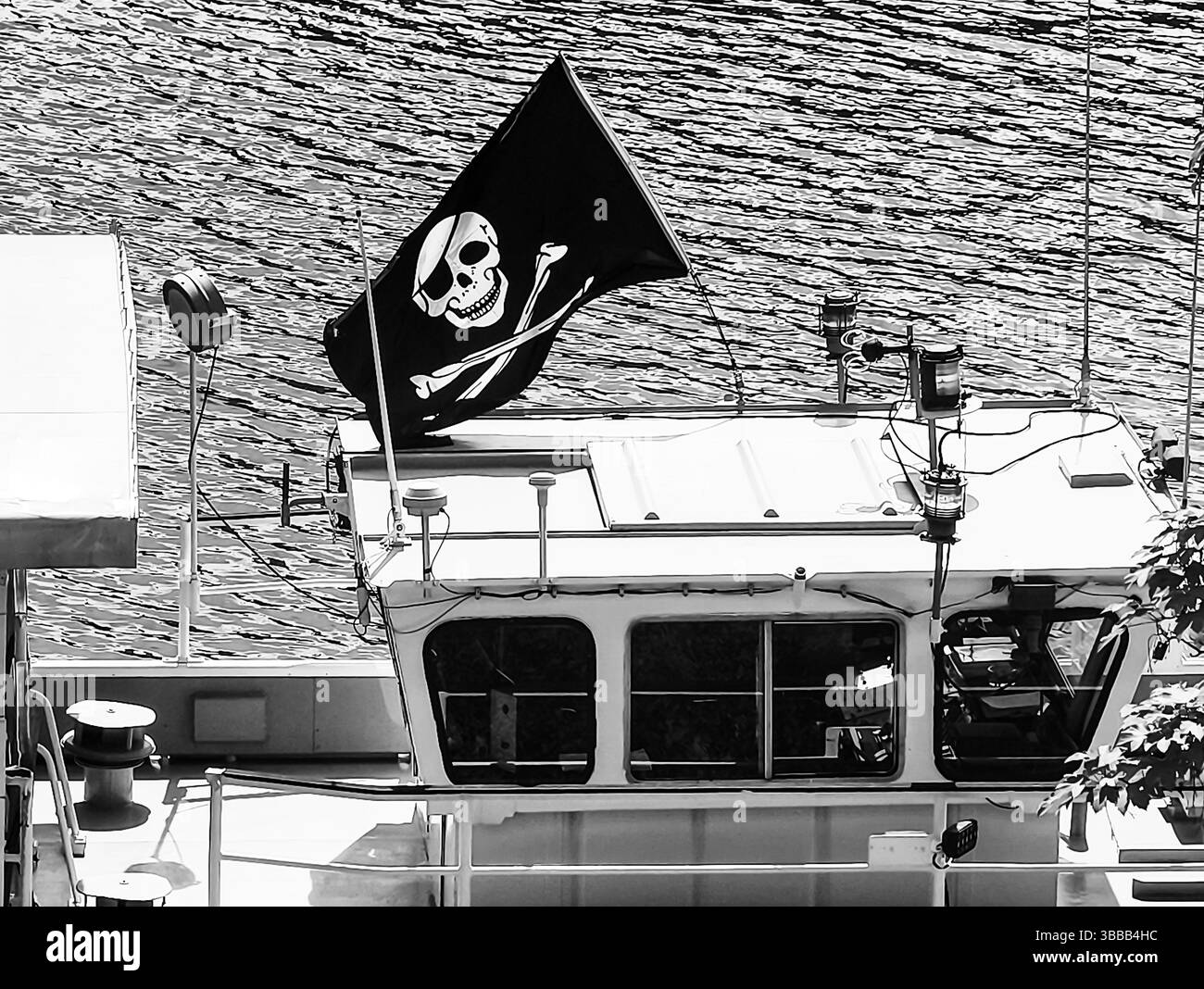 Schwarz-weiß-Bild eines Bootes mit einer Piratenflagge mit Schädel und Kreuzknochen, die ein Gefühl von Abenteuer und nautisches Mysterium wecken, perfekt für Themen der Erkundung und der Hochsee Stockfoto