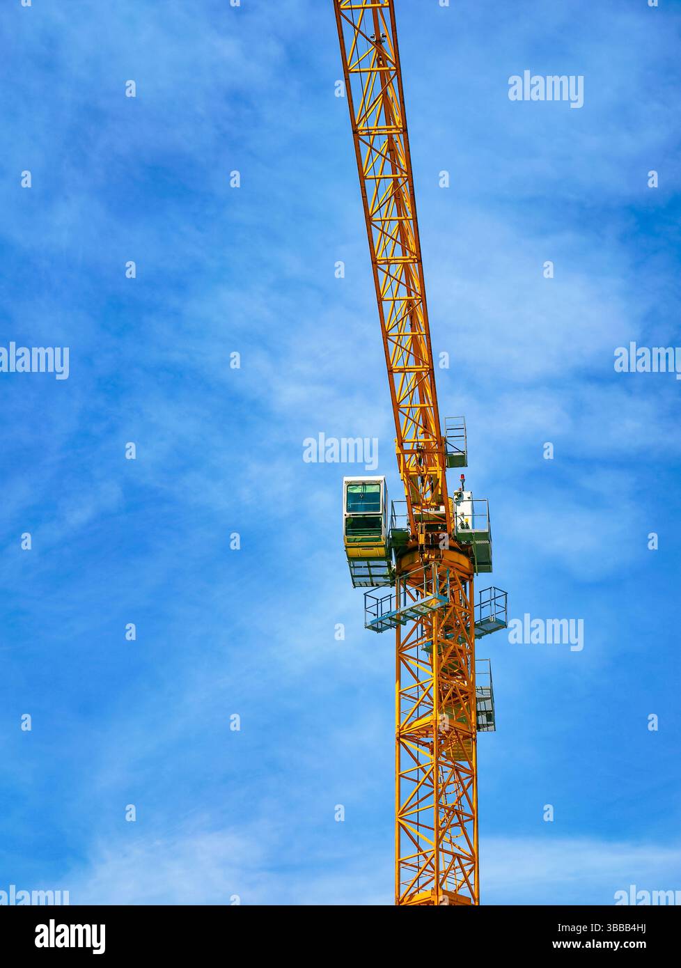 Hoher Baukran, der vor einem klaren blauen Himmel thront und die moderne Technik und Stadtentwicklung symbolisiert, ideal für die Darstellung des Baufortschritts und des architektonischen Fortschritts Stockfoto