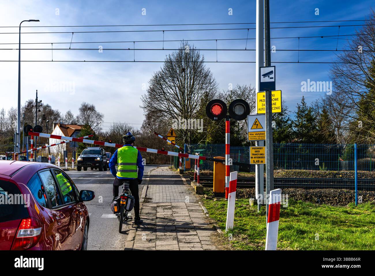 Radfahrer, der vor einer geschlossenen Schranke an einem Bahnübergang wegläuft, rote Warnleuchte kein Einstieg in die Bahngleise Stockfoto