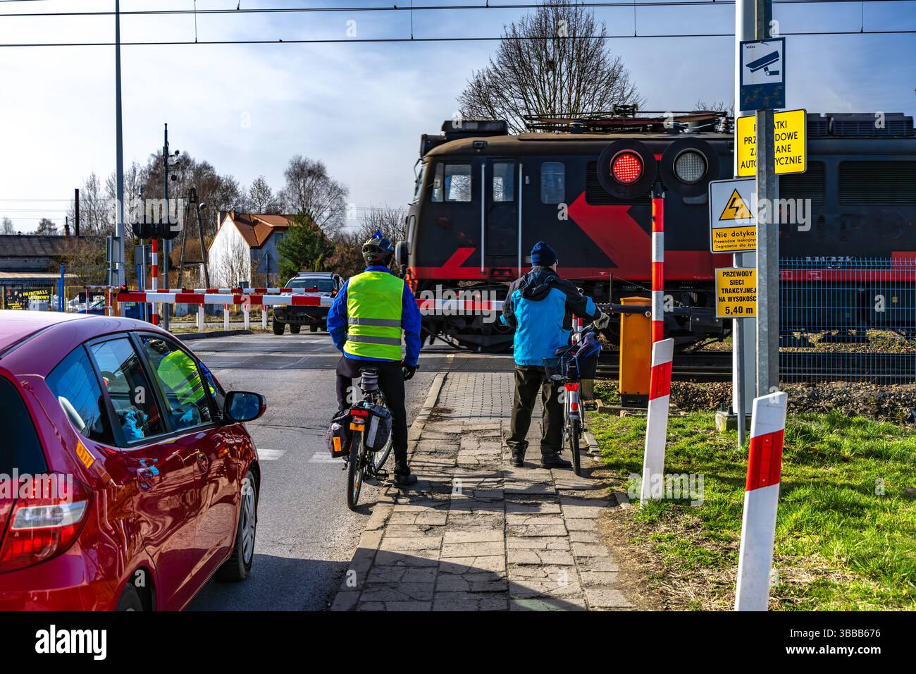 Radfahrer, der vor einer geschlossenen Schranke an einem Bahnübergang wegläuft, rote Warnleuchte kein Einstieg in die Bahngleise Stockfoto