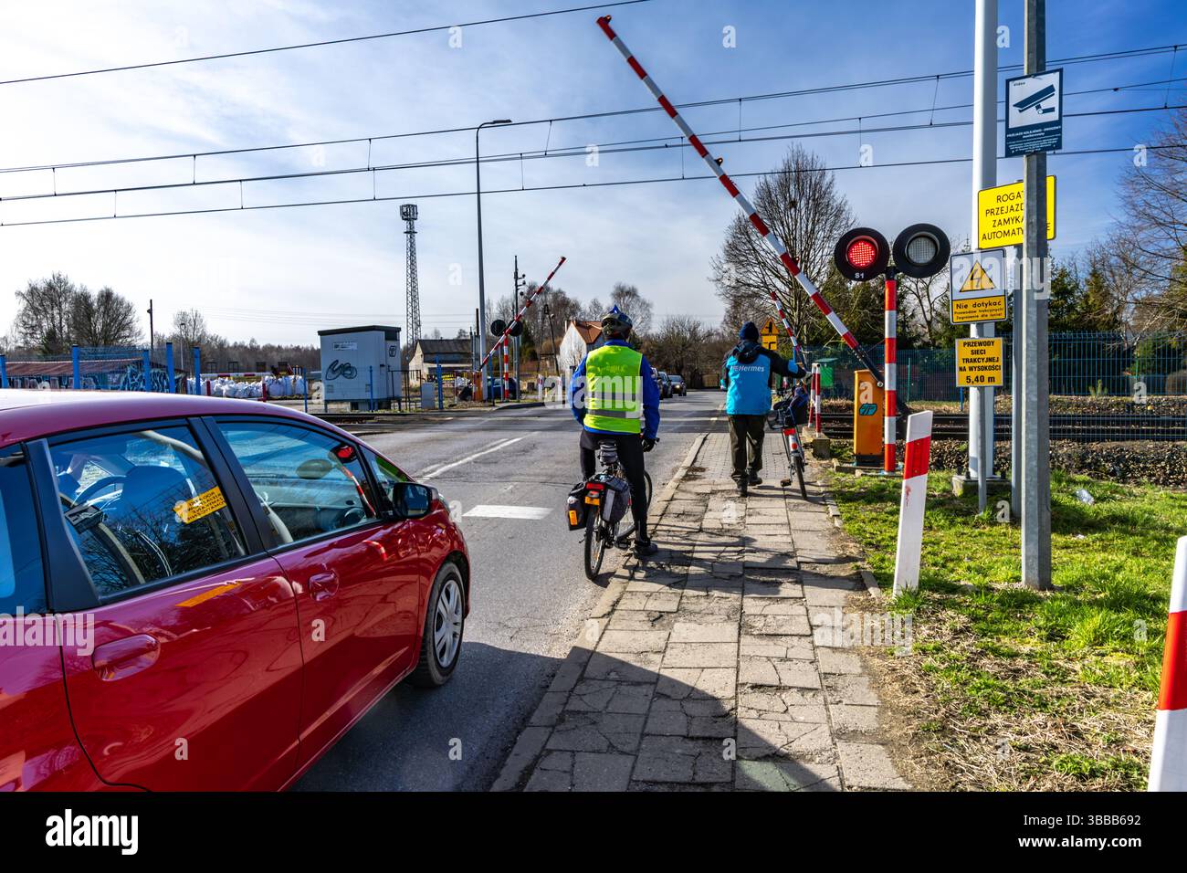 Radfahrer, der vor einer geschlossenen Schranke an einem Bahnübergang wegläuft, rote Warnleuchte kein Einstieg in die Bahngleise Stockfoto