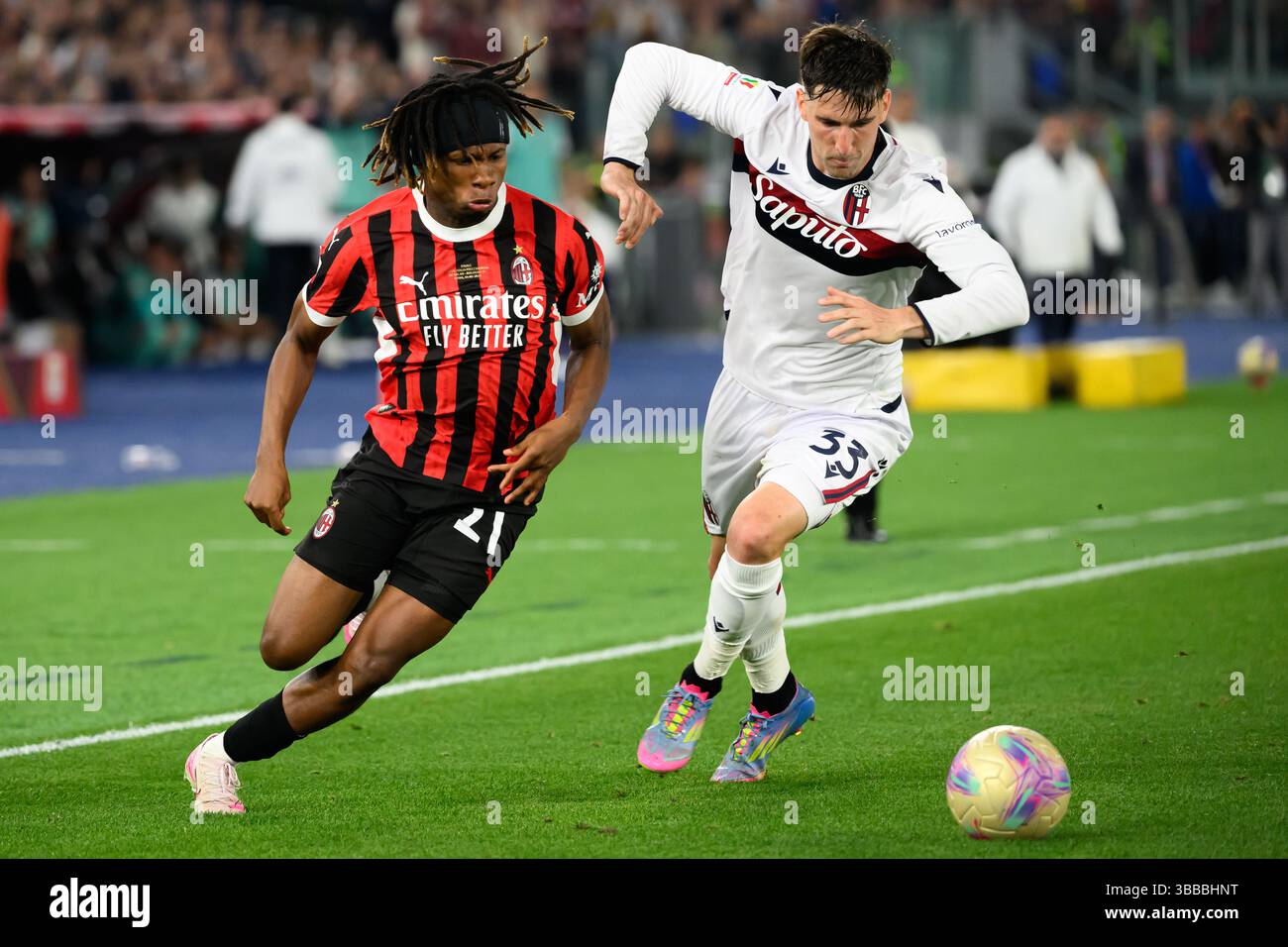 Samuel Chukwueze vom AC Milan und Juan Miranda vom Bologna FC treten um den Ball beim Finale des Coppa Italia zwischen AC Milan und Bologna FC im Stadio Olimpico in Rom (Italien) am 14. Mai 2025 an. Stockfoto