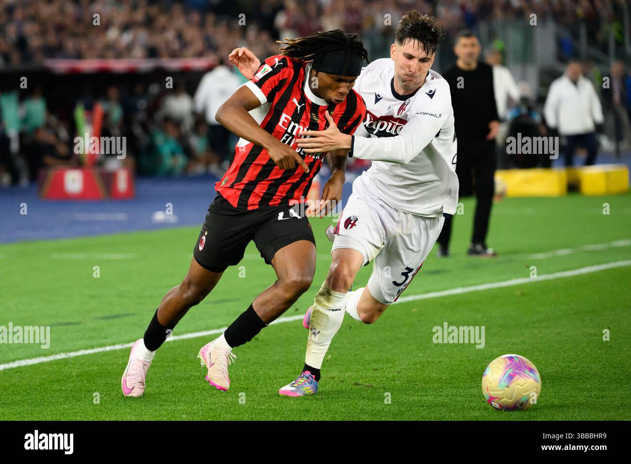 Samuel Chukwueze vom AC Milan und Juan Miranda vom Bologna FC treten um den Ball beim Finale des Coppa Italia zwischen AC Milan und Bologna FC im Stadio Olimpico in Rom (Italien) am 14. Mai 2025 an. Stockfoto