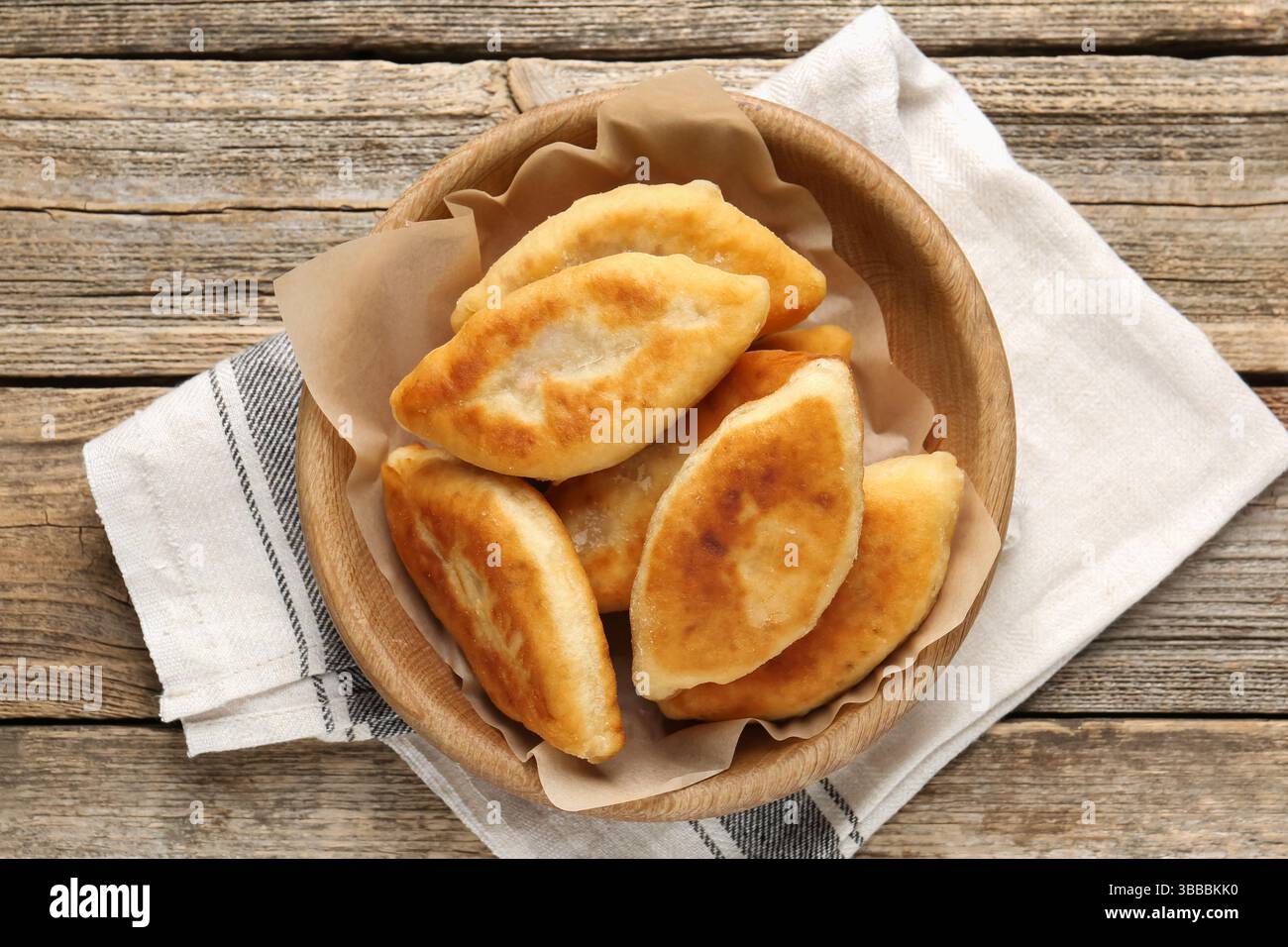Köstliche gebratene Pyrizhky (gefüllte Kuchen) auf Holztisch, Blick von oben Stockfoto Köstliche gebratene Pyrizhky (gefüllte Kuchen) auf Holztisch, Blick von oben Stockfoto