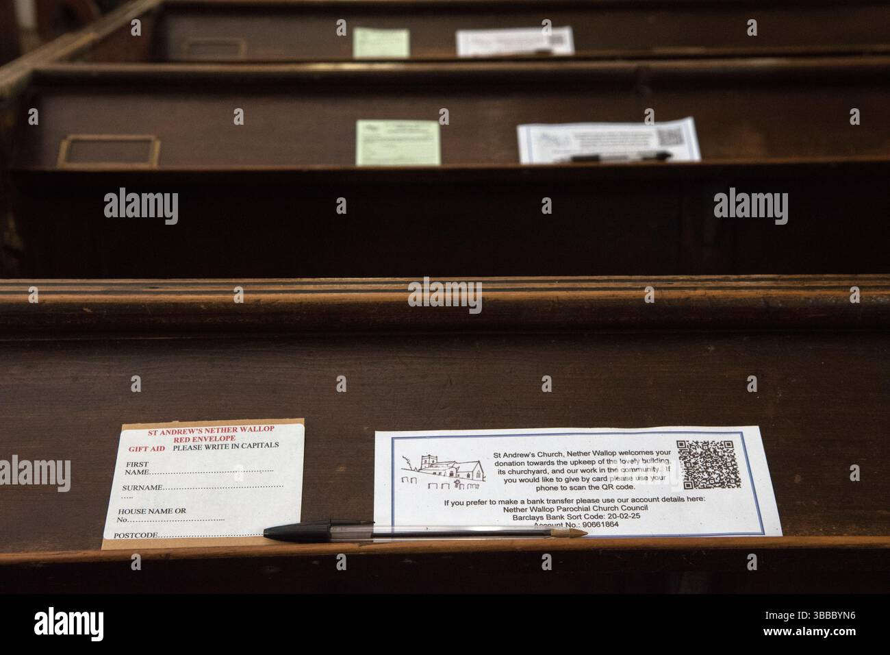 QR-Code UK. Die Quick-Response-Codes ermöglichen es Gemeindemitgliedern und Besuchern in einer bargeldlosen Gesellschaft, eine Spende zu tätigen – eine Spende an die Kirche zu geben, indem sie den Q R Code mit einem Mobiltelefon scannen. Auf dem Bibelregal auf einer Kirchenbank. Geschenkgutschein und biro. St. Andrews Church, Nether Wallop. Hampshire England 2020s UK 2025 HOMER SYKES Stockfoto