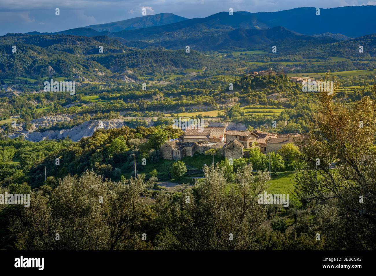 Natursteindorf in bergiger Landschaft mit grünen Tälern und Terrassen. Traditionelle ländliche Architektur in den aragonesischen Pyrenäen in der Nähe von Guaso, Huesc Stockfoto