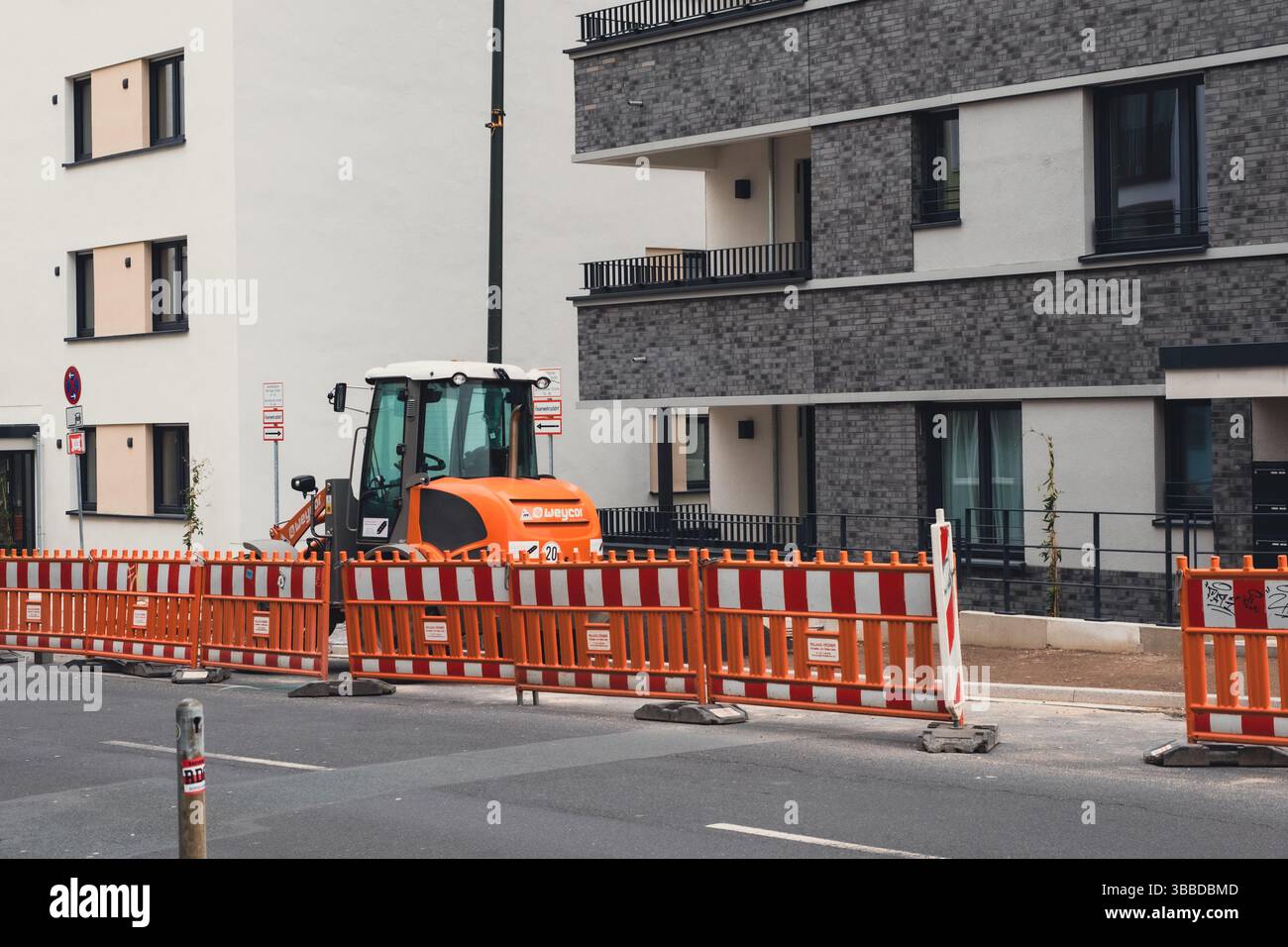 Bautraktor vor neu erbauten Wohnungen in der Gerresheimer Straße Stockfoto
