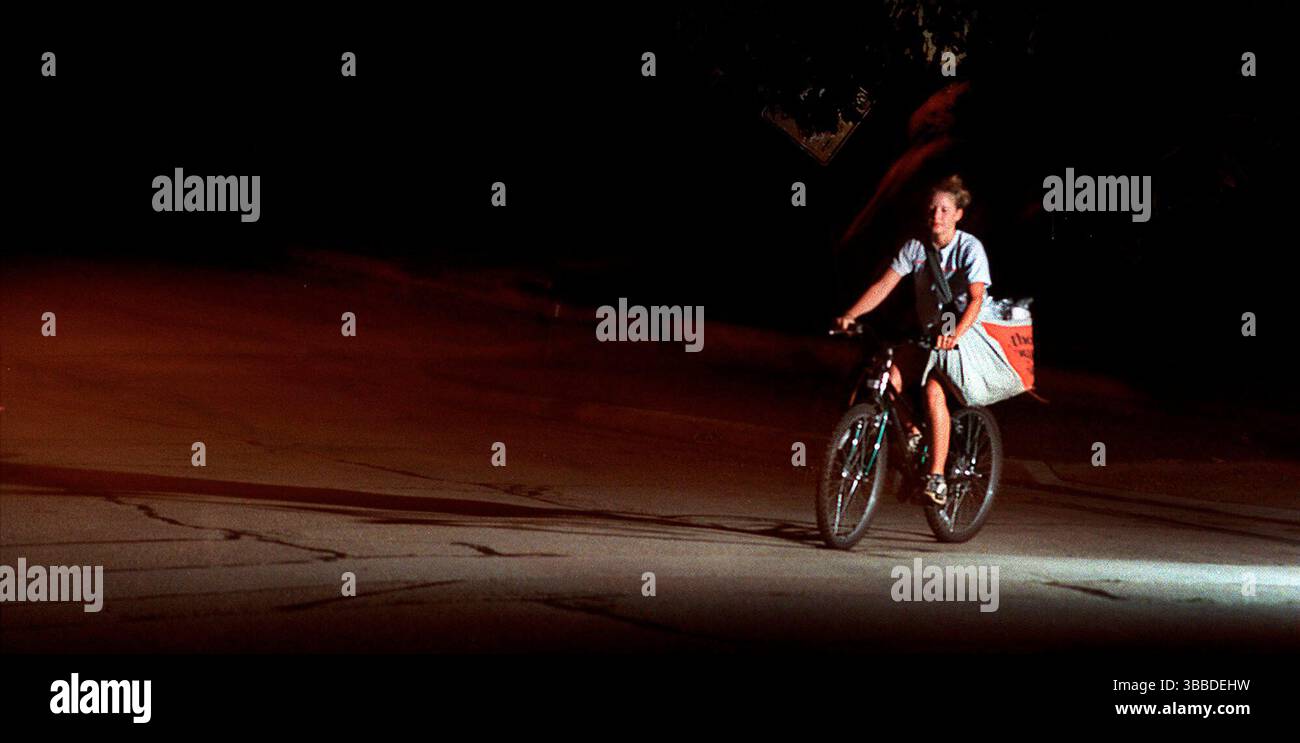 FILE - Christine Bartlett rides her bike between houses as she delivers The Journal Times early Tuesday morning, Aug. 28, 2001, in Racine, Wis. (Gregory Shaver/The Journal Times via AP) Stockfoto