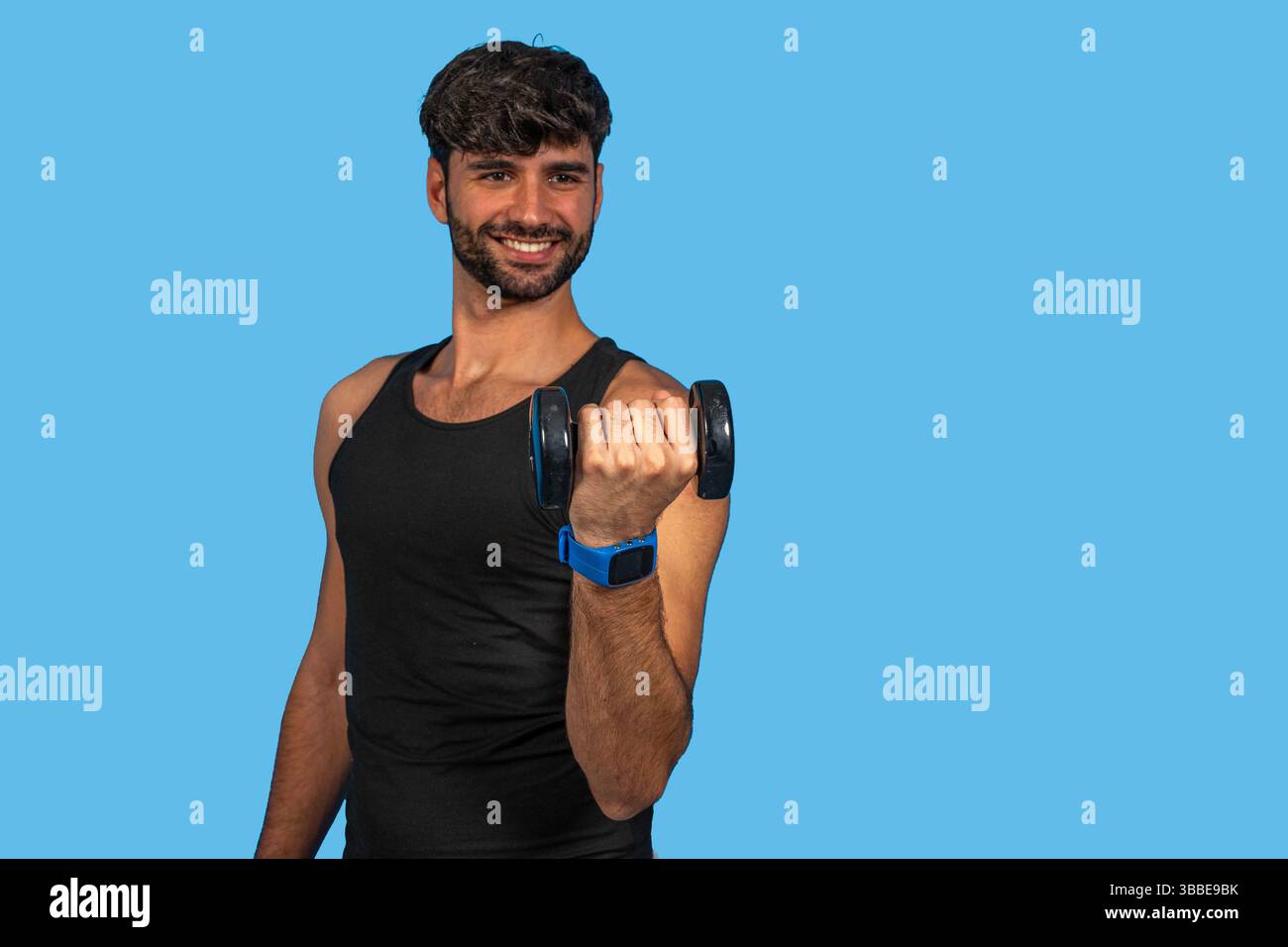 Sportlicher Mann, der eine Smartwatch trägt und mit Kurzhanteln arbeitet, um einen gesunden Lebensstil zu fördern Stockfoto
