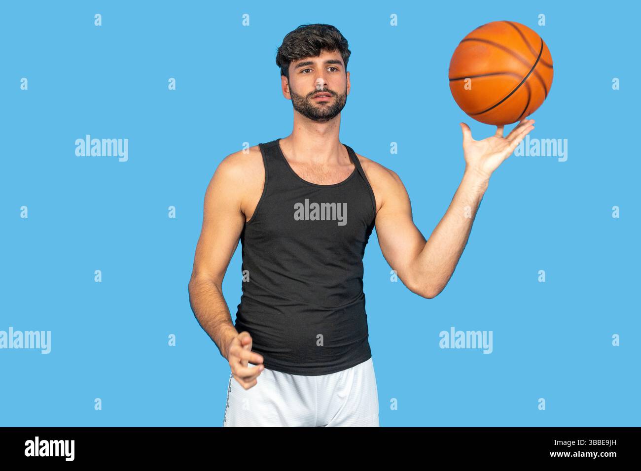 Junger Mann, der geschickt einen Basketball auf seinem Finger dreht Stockfoto