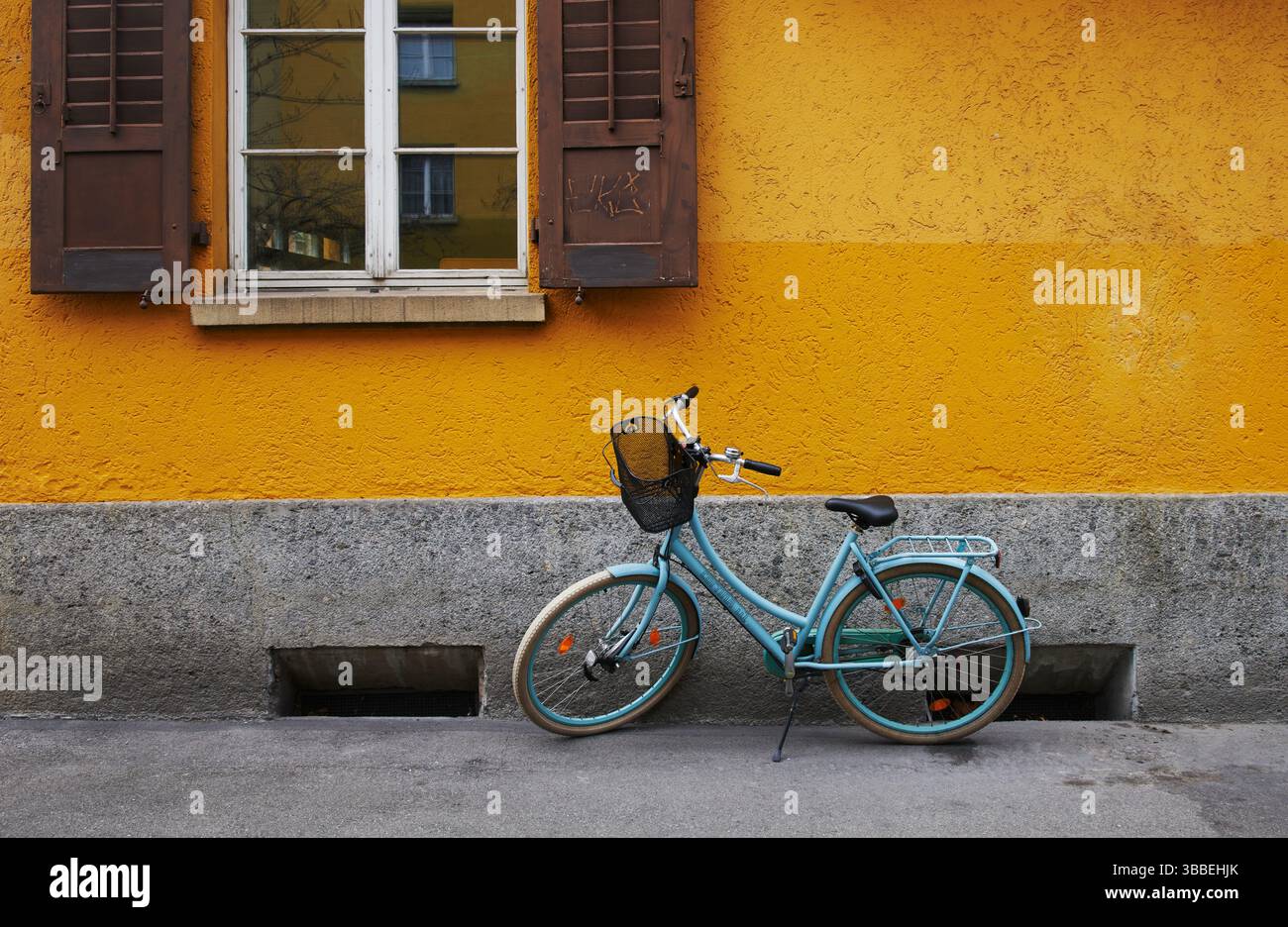 Türkisfarbenes Fahrrad vor einer gelben Wand, Zürich, Schweiz, Europa Stockfoto