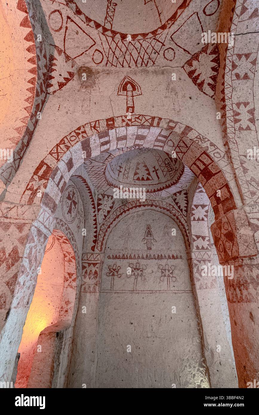 Geometrische Fresken und Symbole in rotem Ocker zieren die Decke der St. Barbara Kapelle, Goreme, die byzantinische Ikonographie widerspiegelt. Stockfoto