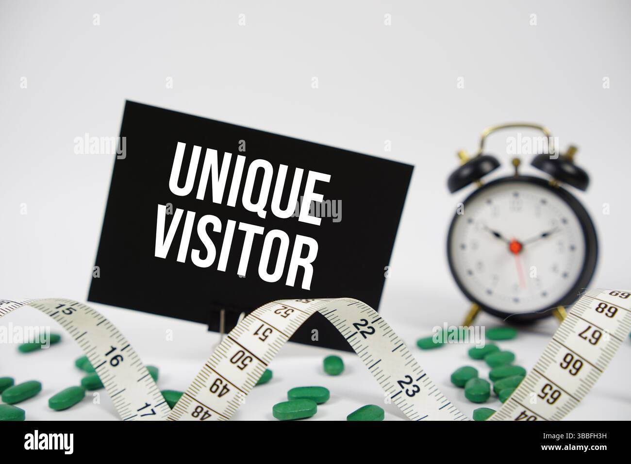 Einzigartiger Besuchertext mit Wecker und Maßband auf weißem Hintergrund Stockfoto