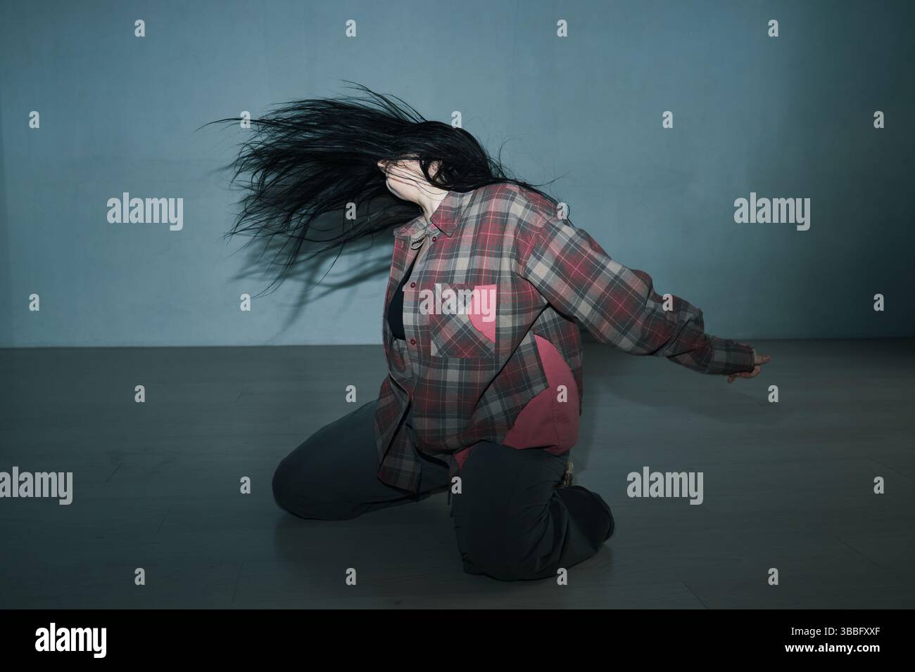 Ausdrucksstarker Tänzer, der in schwach beleuchtetem Raum auftritt Stockfoto