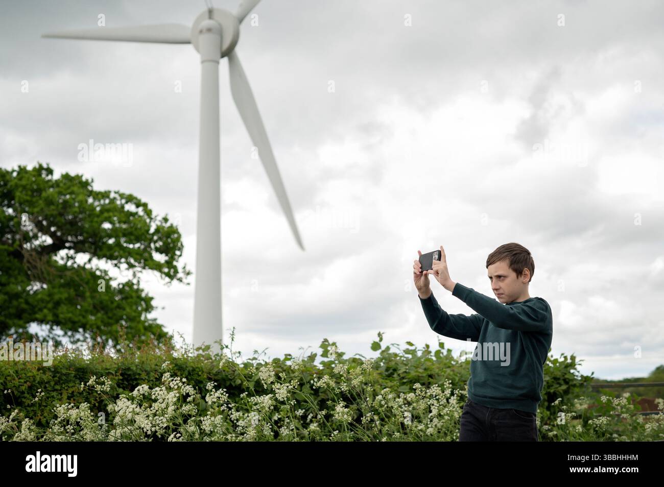 Teenager Junge fotografiert in der Nähe von Windkraftanlagen. Stockfoto