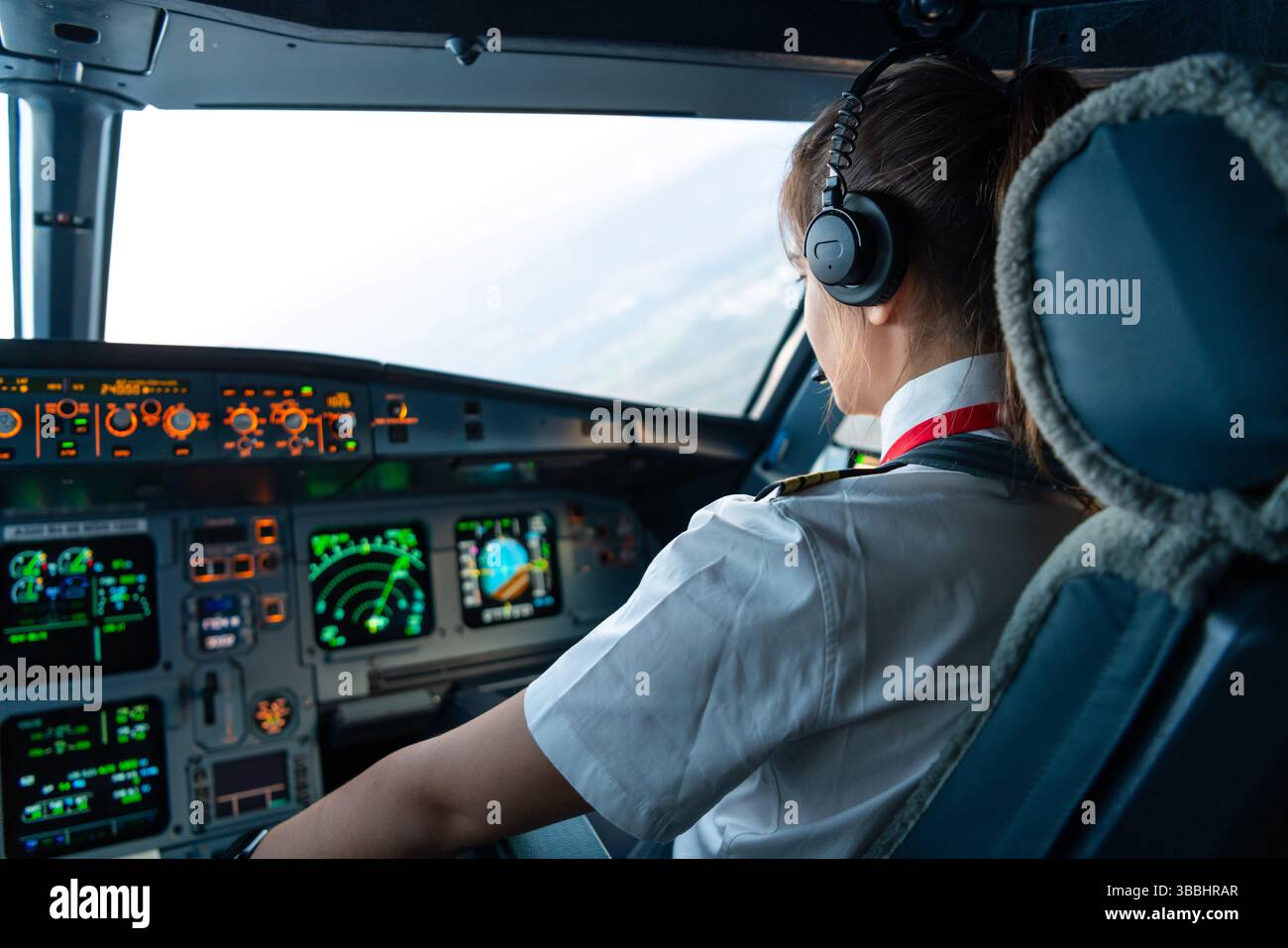 Weibliche Pilotin, die während der Kreuzfahrtphase ein kommerzielles Flugzeug fliegt Stockfoto