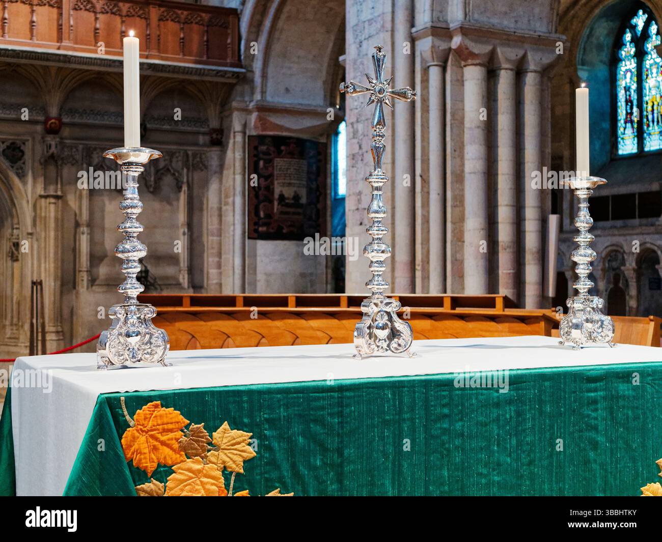 Der Altar befindet sich im Kirchenschiff der Kathedrale von Norwich, der für tägliche Gottesdienste genutzt wird und das einfache Altartuch, das silberne Kreuz und die Kerzenleuchter zeigt. Stockfoto