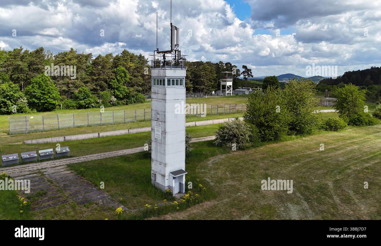 Rasdorf, Deutschland. Mai 2025. Ein DDR-Grenzturm und das US-Lager „Point Alpha“ an der ehemaligen innerdeutschen Grenze, aufgenommen am Tag des 35. Jahrestages der Zeremonie „Last Border Patrol“ anlässlich der letzten US-Army-Patrouille entlang der innerdeutschen Grenze zwischen Rasdorf und Geisa (Foto mit Drohne). Mit dieser Zeremonie würdigt die Point Alpha Foundation den Dienst der US-Soldaten, die über vier Jahrzehnte lang an der innerdeutschen Grenze patrouillierten. Quelle: Martin Schutt/dpa/Alamy Live News Stockfoto