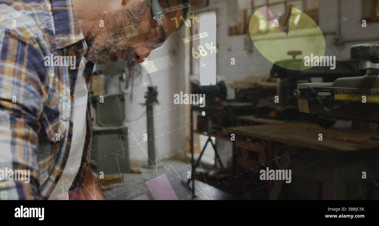 Anlehnender Zimmermann, der Holzstücke an der Werkstattwerkbank bearbeitet, mit Kapselgehörschützern und Tischsäge Stockfoto