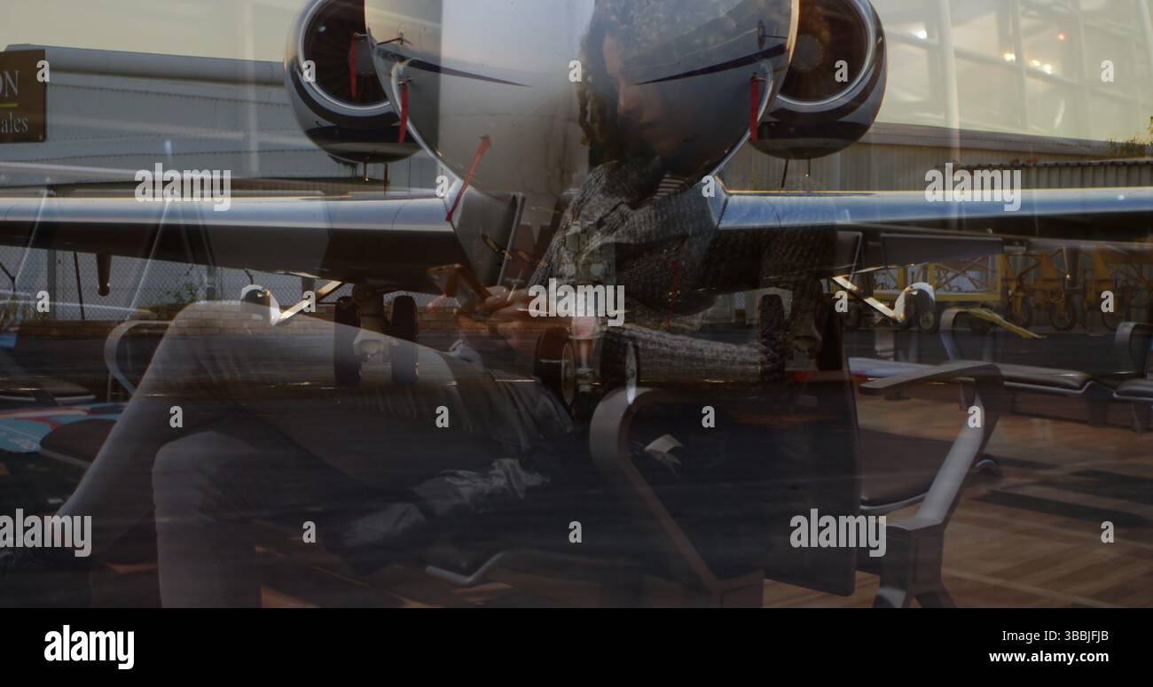 Smartphone und Stift in der Hand, weibliche Reisende tippen Nachricht in der Flughafenlounge, Privatjet sichtbar Stockfoto