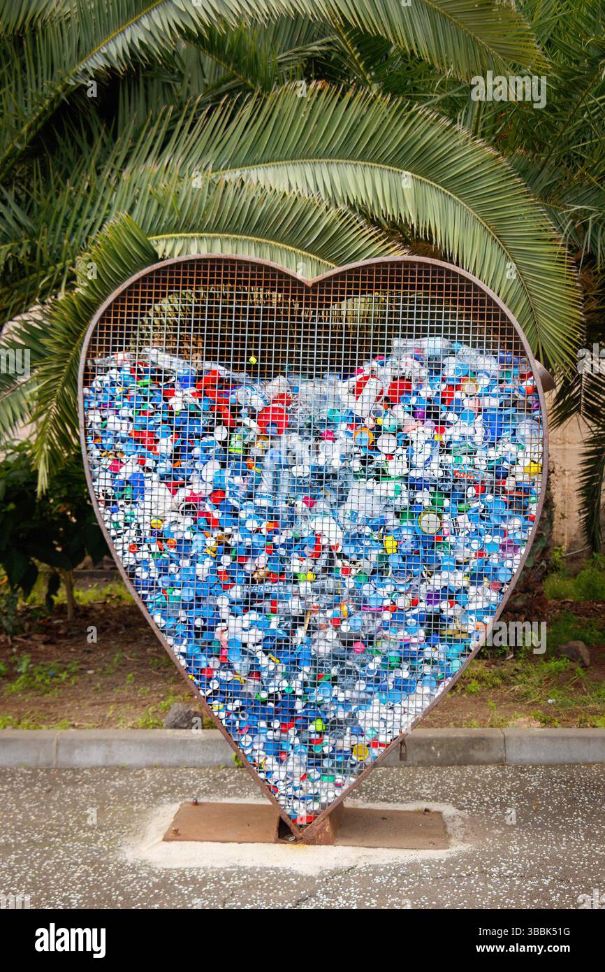 Plastikabfallflaschen und -Kartons hinter Gittern in Herzform in santa cruz de teneriffa Stockfoto