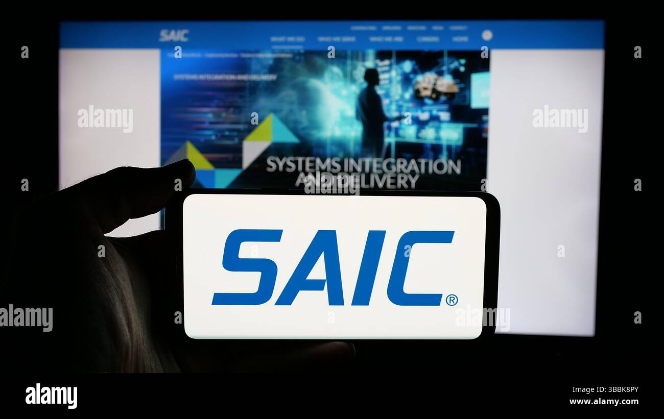 Stuttgart, Deutschland - 01-07-2024: Person mit Mobiltelefon mit Logo der Science Applications International Corporation (SAIC) auf dem Bildschirm Stockfoto