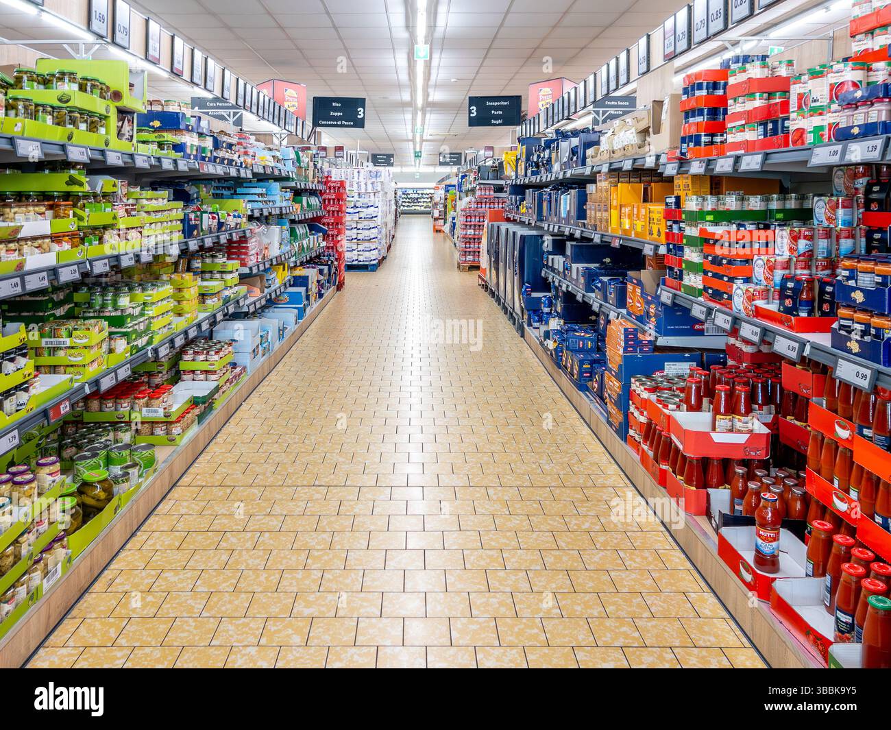 Fossano, Italien - 15. Mai 2024: Gang mit Regalen mit Packungen Tomatensoße, Nudeln und Konserven in einem Lidl-Supermarkt, einem Discount-Geschäft Stockfoto