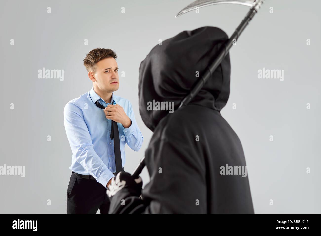 Grim Reaper Besucht Verängstigten Mann Auf Grauem Hintergrund Mit Scythe Stockfoto