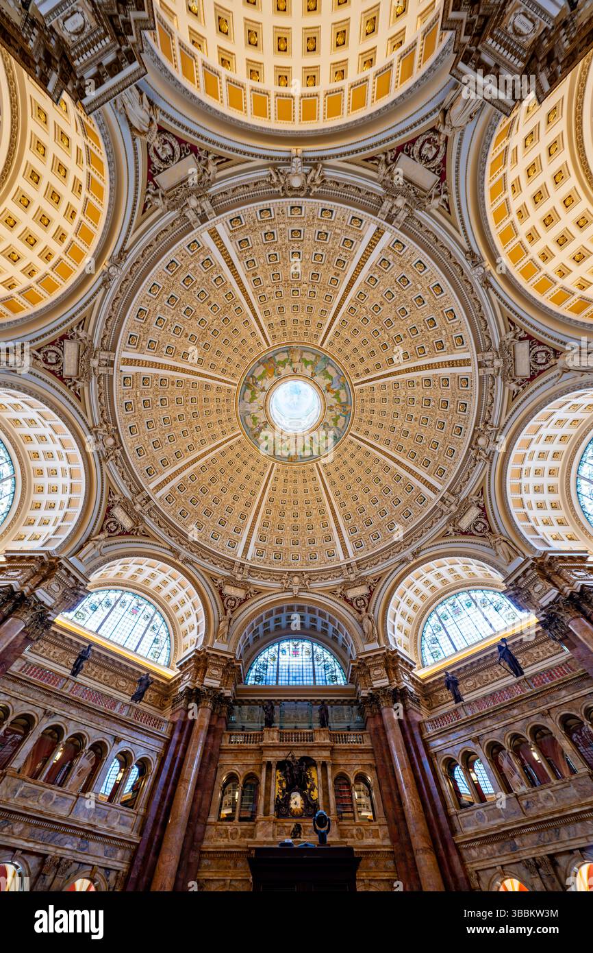 WASHINGTON DC – die reich verzierte Kuppeldecke des Hauptlesungssaals im Thomas Jefferson Building der Library of Congress steht für den Höhepunkt des amerikanischen Beaux-Arts-Designs. Die 1897 fertiggestellte 160 Meter hohe Kuppel zeigt Edwin Howland Blashfields zentrales Gemälde „menschliches Verständnis“, umgeben von zwölf Figuren, die Länder und Epochen repräsentieren, die zum menschlichen Wissen beigetragen haben. Die Decke enthält kunstvoll vergoldete Formteile, farbenfrohe allegorische Gemälde im Kragen der Kuppel und Personifizierungen von Literatur, Wissenschaft und Kunst. Dieses Meisterwerk von Amer Stockfoto