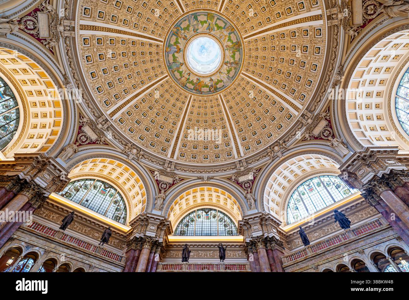 WASHINGTON DC – die reich verzierte Kuppeldecke des Hauptlesungssaals im Thomas Jefferson Building der Library of Congress steht für den Höhepunkt des amerikanischen Beaux-Arts-Designs. Die 1897 fertiggestellte 160 Meter hohe Kuppel zeigt Edwin Howland Blashfields zentrales Gemälde „menschliches Verständnis“, umgeben von zwölf Figuren, die Länder und Epochen repräsentieren, die zum menschlichen Wissen beigetragen haben. Die Decke enthält kunstvoll vergoldete Formteile, farbenfrohe allegorische Gemälde im Kragen der Kuppel und Personifizierungen von Literatur, Wissenschaft und Kunst. Dieses Meisterwerk von Amer Stockfoto