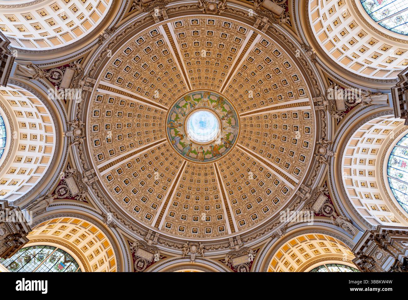 WASHINGTON DC – die reich verzierte Kuppeldecke des Hauptlesungssaals im Thomas Jefferson Building der Library of Congress steht für den Höhepunkt des amerikanischen Beaux-Arts-Designs. Die 1897 fertiggestellte 160 Meter hohe Kuppel zeigt Edwin Howland Blashfields zentrales Gemälde „menschliches Verständnis“, umgeben von zwölf Figuren, die Länder und Epochen repräsentieren, die zum menschlichen Wissen beigetragen haben. Die Decke enthält kunstvoll vergoldete Formteile, farbenfrohe allegorische Gemälde im Kragen der Kuppel und Personifizierungen von Literatur, Wissenschaft und Kunst. Dieses Meisterwerk von Amer Stockfoto