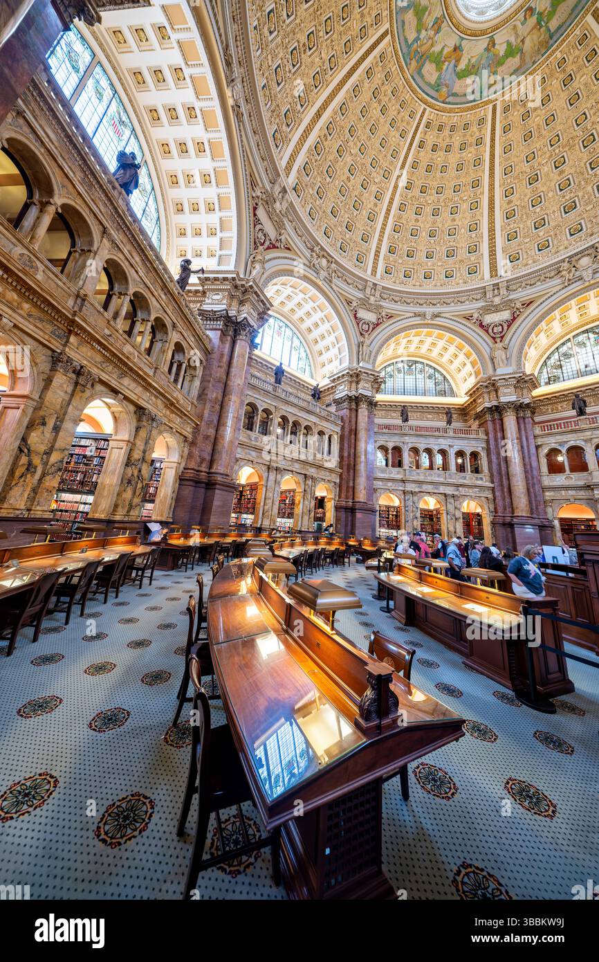 WASHINGTON DC – der Hauptlesungsraum des Thomas Jefferson Building in der Library of Congress ist einer der prächtigsten öffentlichen Räume Amerikas. Dieser achteckige Raum wurde 1897 fertiggestellt und erhebt sich 160 Meter zu einer kunstvollen Kuppel mit Edwin Howland Blashfields Gemälde „menschliches Verständnis“, umgeben von allegorischen Figuren, die Länder repräsentieren, die zum menschlichen Wissen beigetragen haben. Der Lesesaal verfügt über massive Säulen aus rotem Marmor mit vergoldeten korinthischen Kapitellen, Bronzestatuen, die Wissensfelder darstellen, und drei Reihen von Bücherstapeln, die den zentralen Raum umkreisen. Entwickelt Stockfoto