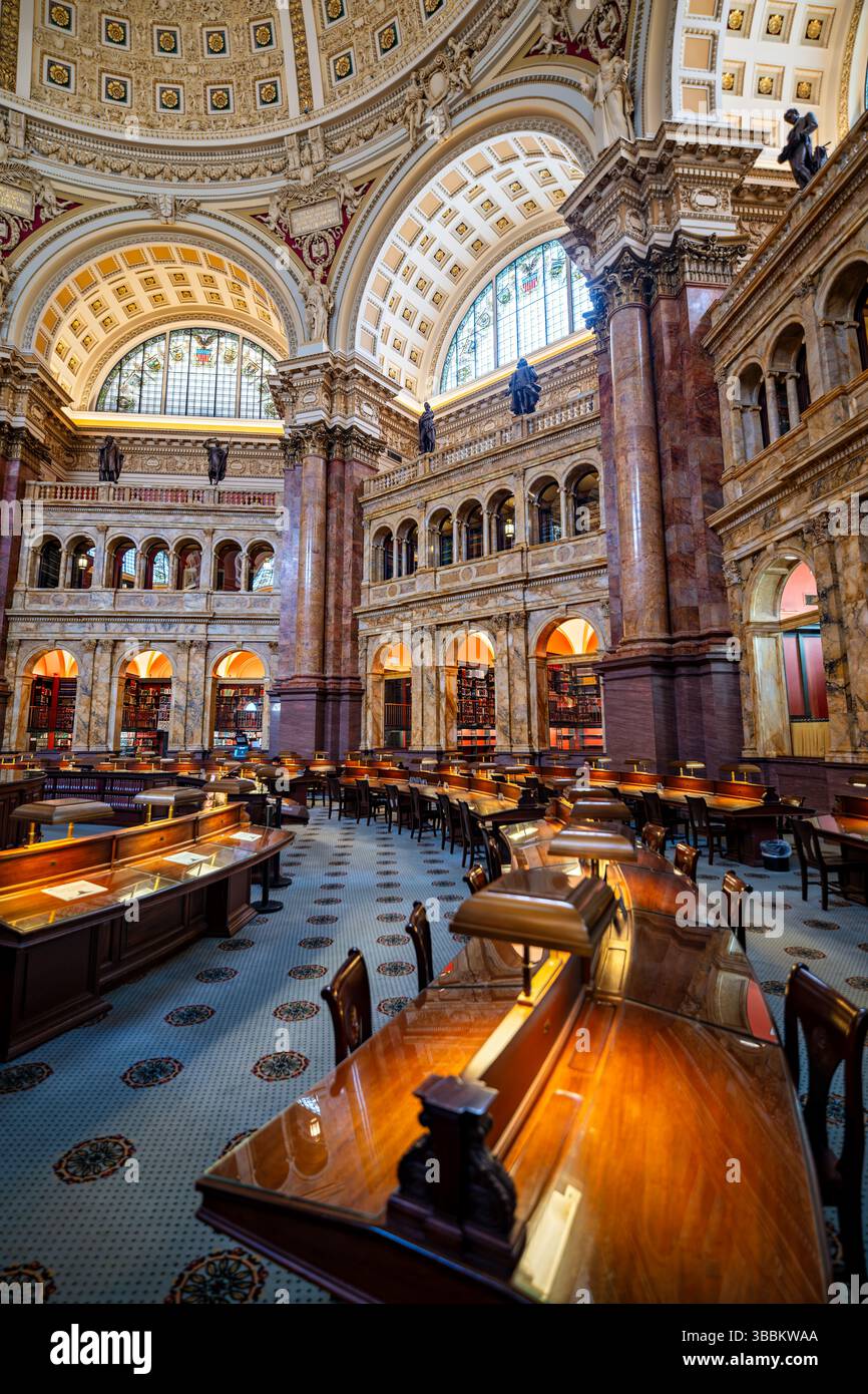 WASHINGTON DC – der Hauptlesungsraum des Thomas Jefferson Building in der Library of Congress ist einer der prächtigsten öffentlichen Räume Amerikas. Dieser achteckige Raum wurde 1897 fertiggestellt und erhebt sich 160 Meter zu einer kunstvollen Kuppel mit Edwin Howland Blashfields Gemälde „menschliches Verständnis“, umgeben von allegorischen Figuren, die Länder repräsentieren, die zum menschlichen Wissen beigetragen haben. Der Lesesaal verfügt über massive Säulen aus rotem Marmor mit vergoldeten korinthischen Kapitellen, Bronzestatuen, die Wissensfelder darstellen, und drei Reihen von Bücherstapeln, die den zentralen Raum umkreisen. Entwickelt Stockfoto