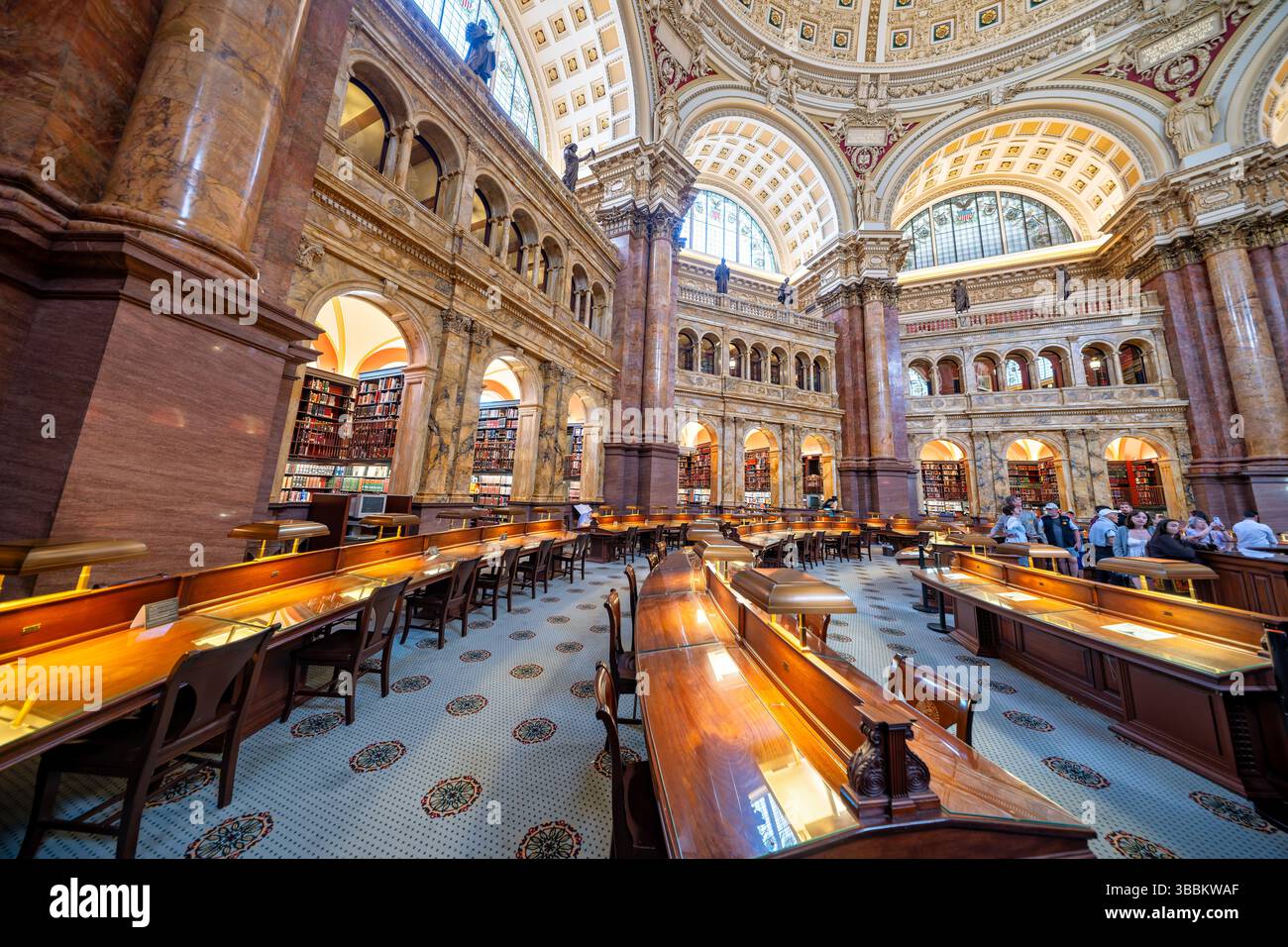 WASHINGTON DC – der Hauptlesungsraum des Thomas Jefferson Building in der Library of Congress ist einer der prächtigsten öffentlichen Räume Amerikas. Dieser achteckige Raum wurde 1897 fertiggestellt und erhebt sich 160 Meter zu einer kunstvollen Kuppel mit Edwin Howland Blashfields Gemälde „menschliches Verständnis“, umgeben von allegorischen Figuren, die Länder repräsentieren, die zum menschlichen Wissen beigetragen haben. Der Lesesaal verfügt über massive Säulen aus rotem Marmor mit vergoldeten korinthischen Kapitellen, Bronzestatuen, die Wissensfelder darstellen, und drei Reihen von Bücherstapeln, die den zentralen Raum umkreisen. Entwickelt Stockfoto
